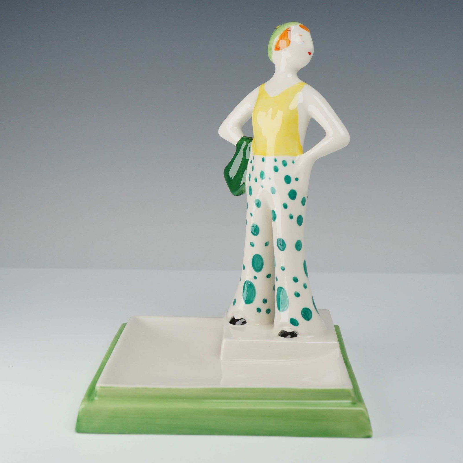 Wedgwood Clarice Cliff Collectors Club Figurine, 1999 Centenary Collection: A Wedgwood hand-painted ceramic figurine produced for the Clarice Cliff Collectors Club as part of the 1999 Centenary Collection. The piece depicts a female figure in Art Deco-style resort wear, inclu