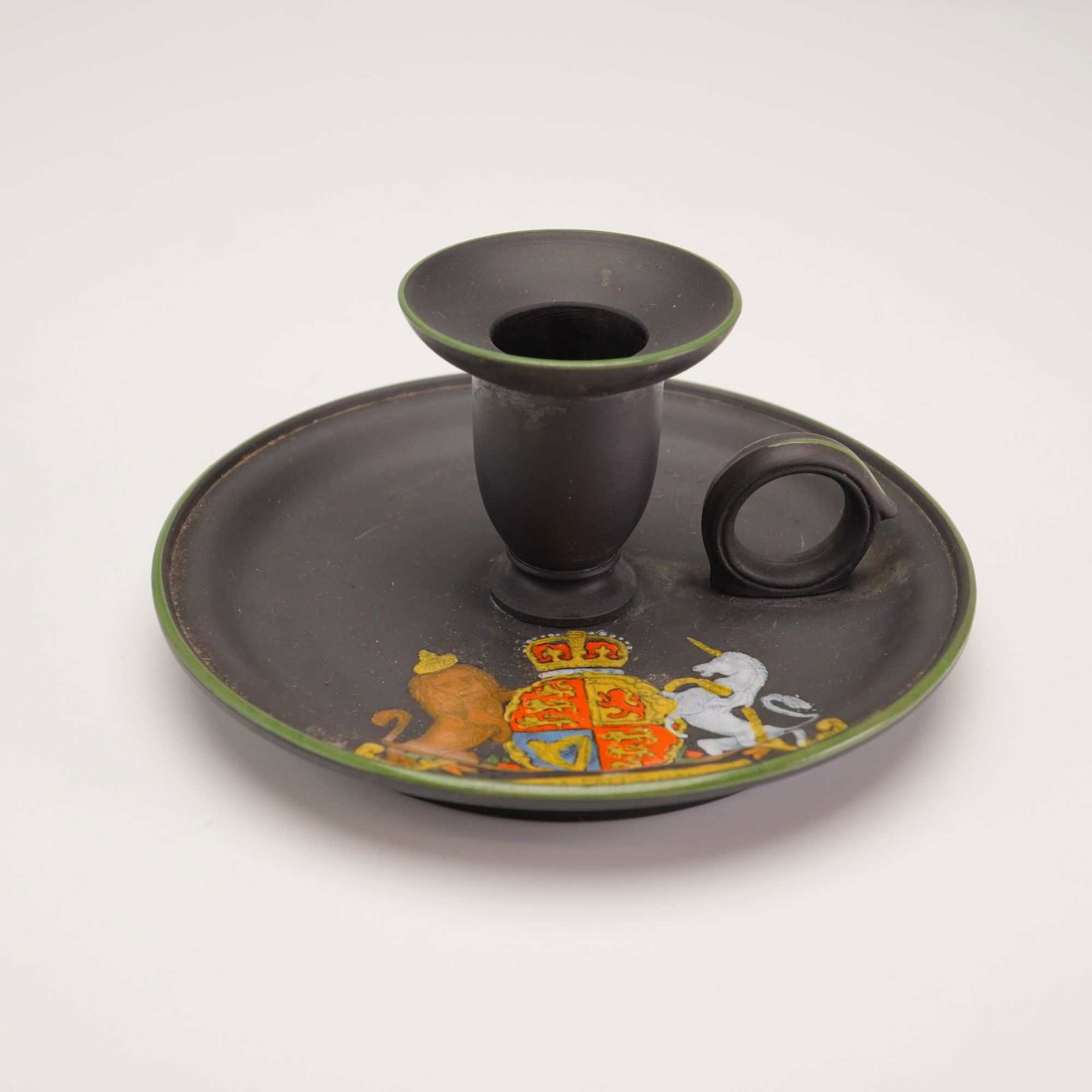 Wedgwood Black Basalt Chamberstick: This Wedgwood black basalt chamberstick, sourced from the Rubin Collection, was produced as a souvenir for the Niagara Falls, Canada, tourist market. The piece is crafted from unglazed black stoneware