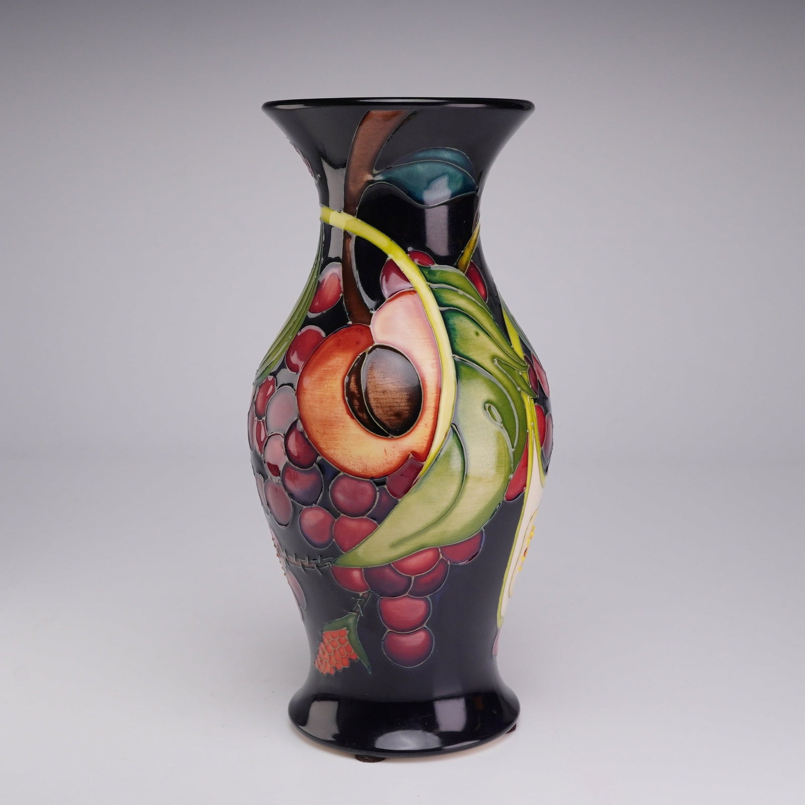 Moorcroft Pottery by Emma Bossons Vase, Queens Choice: The piece features a baluster form with a flared neck and rim, tapering to a slightly spreading circular base. The decoration is executed using the tubelining technique, where raised slip lines create