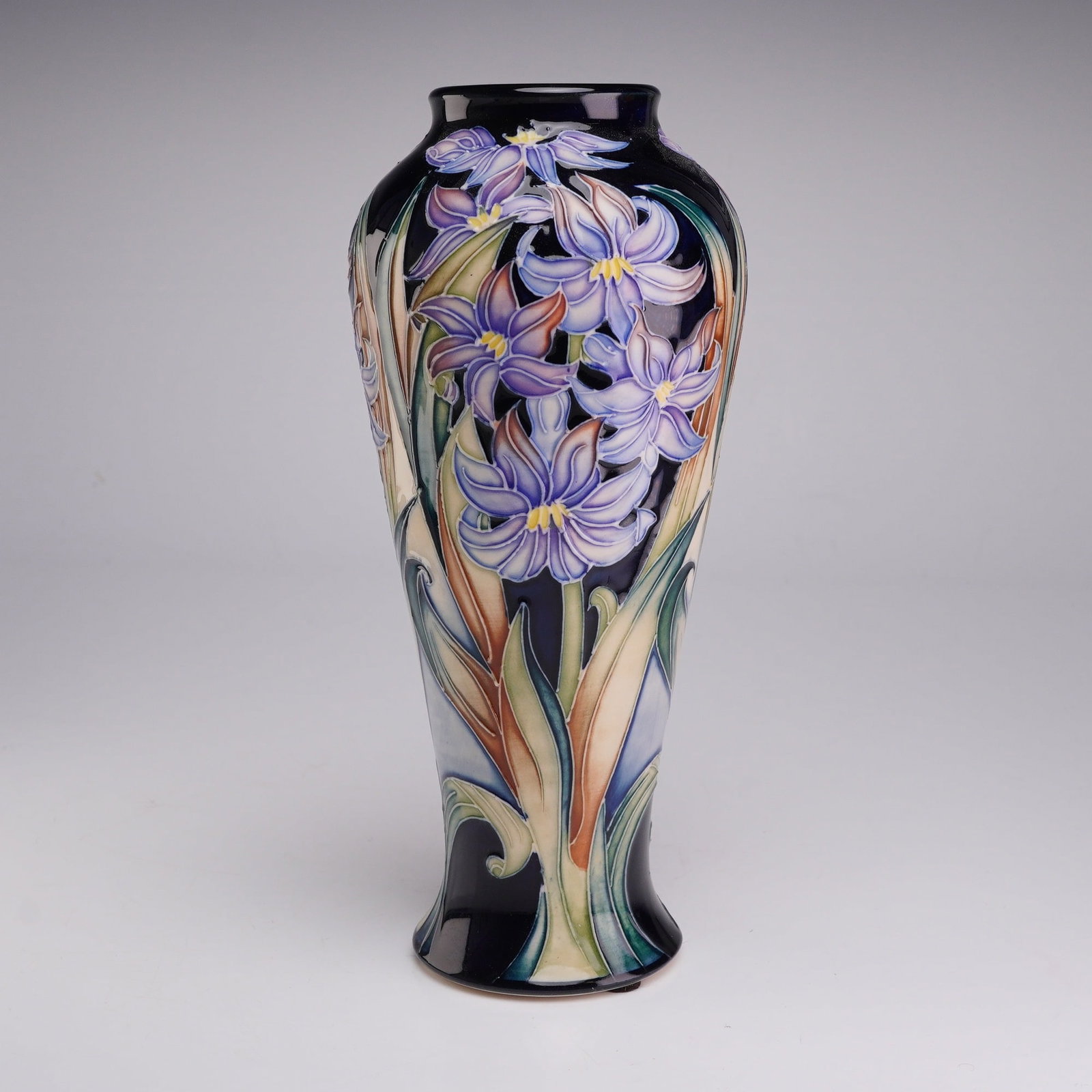 Moorcroft Pottery by Rachel Bishop Limited Edition Vase, Siberian Iris: This Moorcroft art pottery earthenware vase features the Siberian Iris pattern. The vessel is designed in a slender, tapered baluster form with a flared foot and a short neck. The exterior is decorate