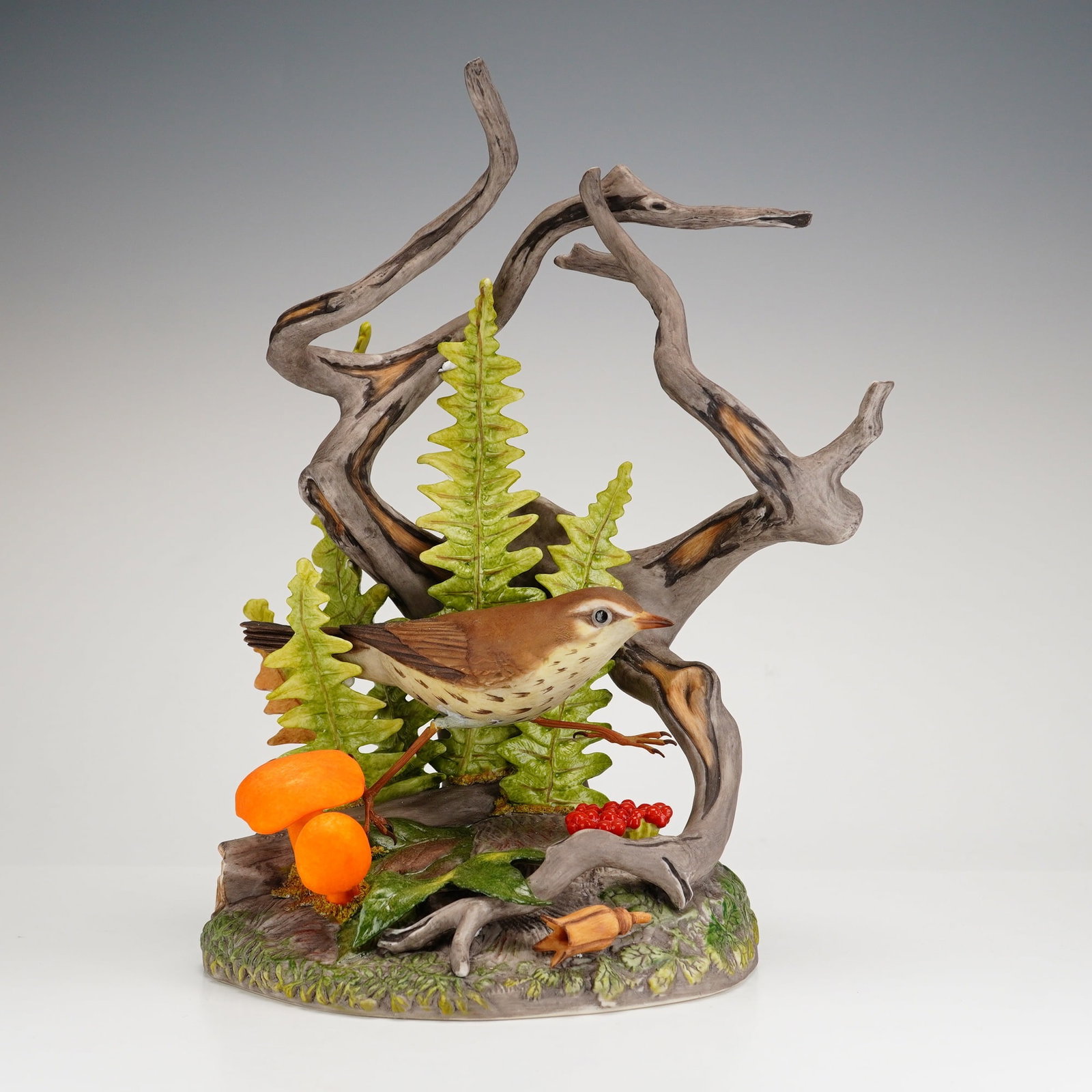 Boehm Porcelain Figurine, Northern Water Thrush 490: This porcelain figurine is modeled as a northern waterthrush walking on the forest floor, surrounded by leaves, berries, and mushrooms. Marked with the Boehm backstamp. Dimensions: 8.5"L x 6.5"W x 11"