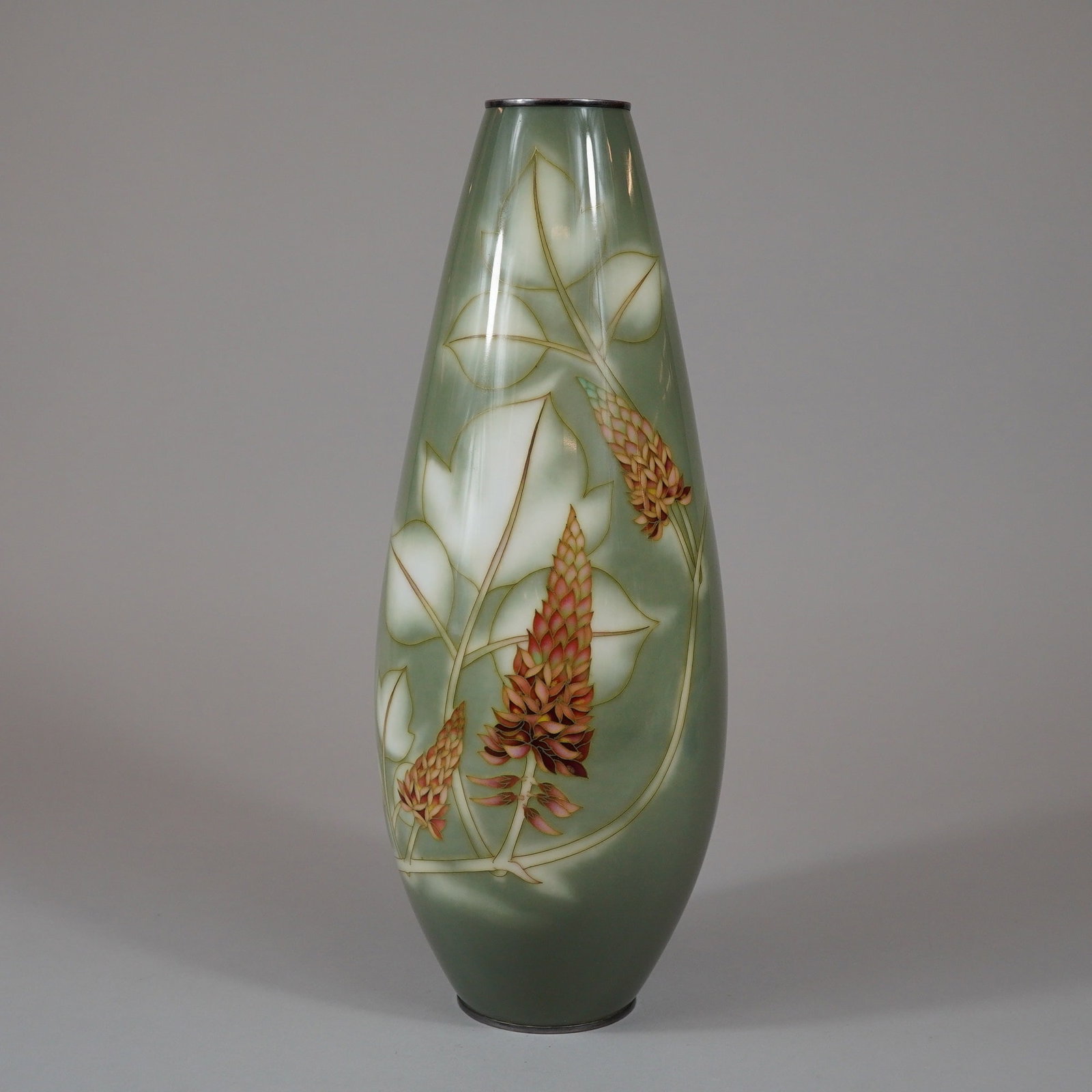 Ando Jubei Company Japanese Cloisonne Silver-Mounted Yusen-Shippo Vase: A tall ovoid Japanese cloisonne enamel vase produced by the Ando Cloisonne Company. The vessel is decorated in the yusen-shippo technique with floral spikes, possibly lupines or andromeda, rendered in