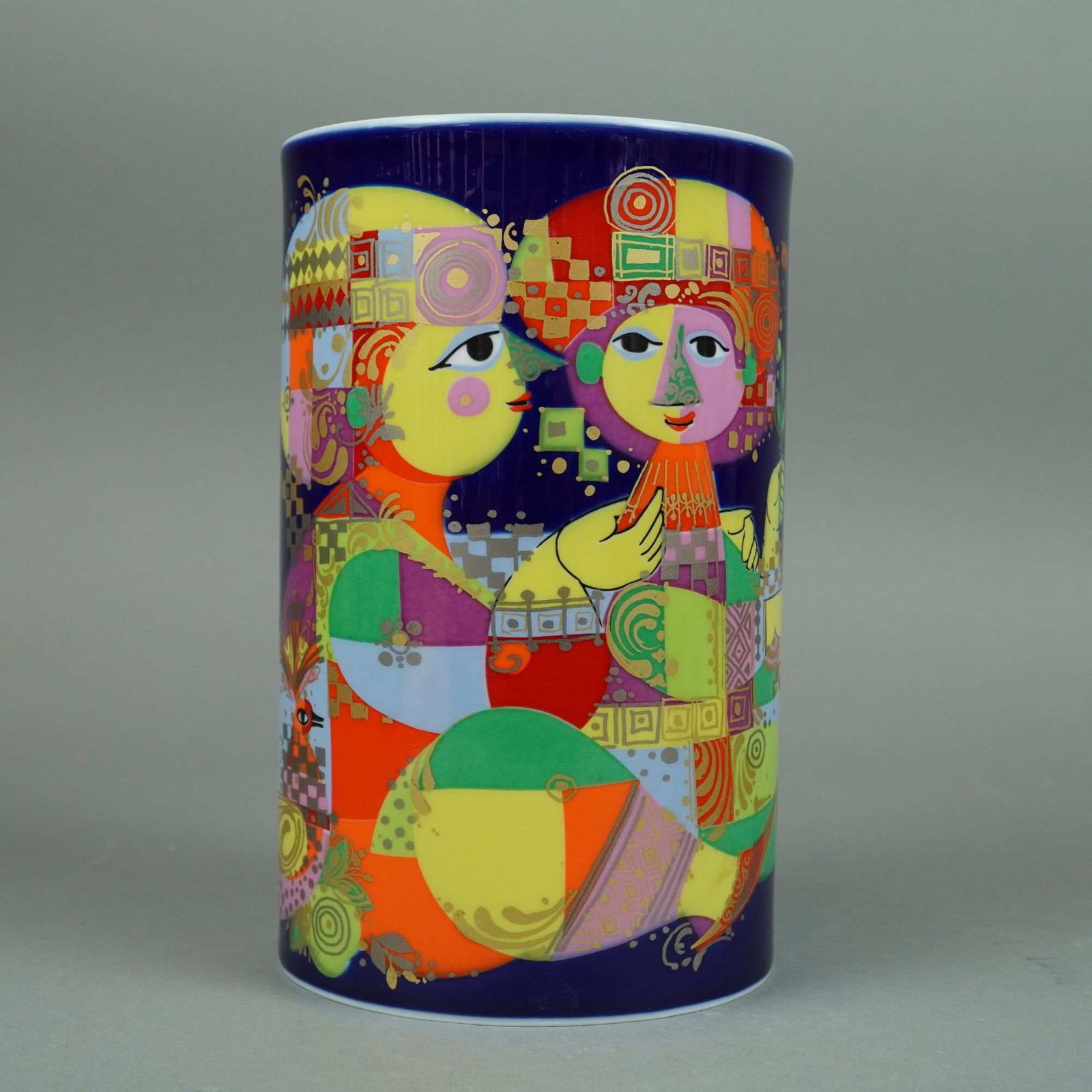 Rosenthal Studio-Line Bjorn Wiinblad 1,001 Nights Porcelain Vase: A cylindrical porcelain vase from the 1,001 Nights series, designed by Bjorn Wiinblad for Rosenthal Studio-Line. The vase is constructed of fine white porcelain with a deep cobalt blue ground. The ext