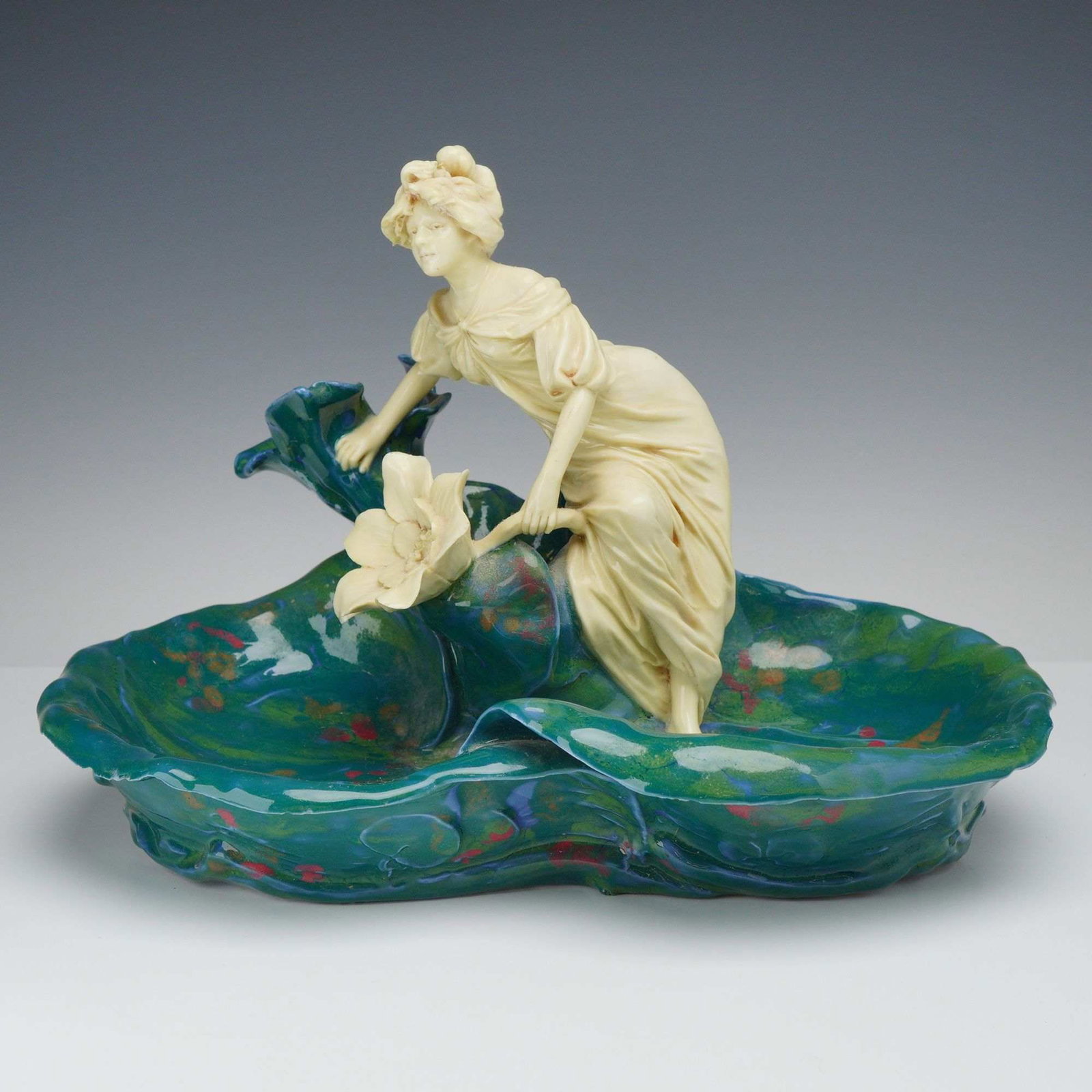 Royal Dux Bohemia Art Nouveau Porcelain Figural Water Nymph Centerpiece Bowl: An Art Nouveau porcelain figural centerpiece bowl by Royal Dux Bohemia, featuring a water nymph. The design consists of a central figure of a woman in classical drapery with a matte ivory-colored bisq