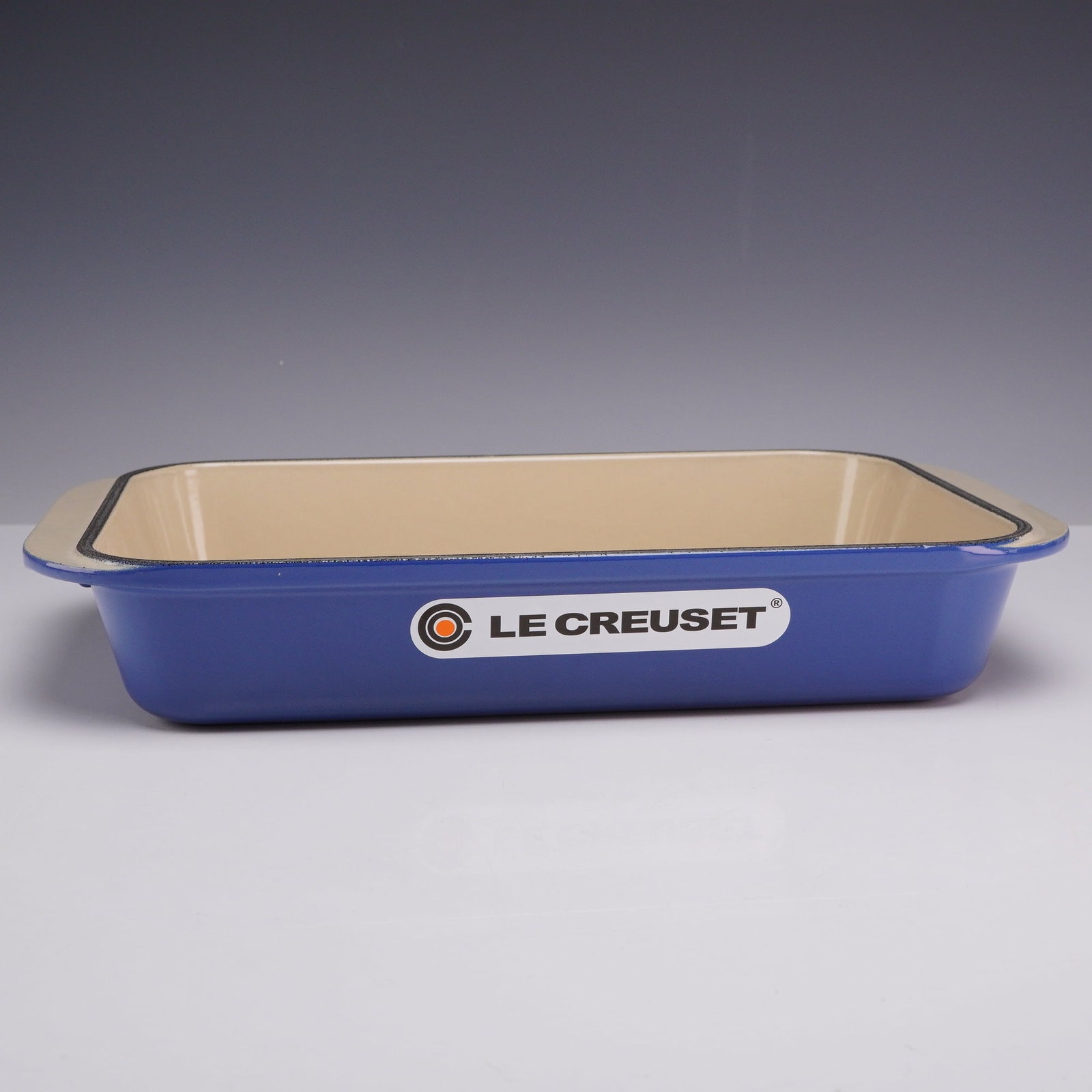 Le Creuset Cobalt Blue Enameled Cast Iron Rectangular Roaster Dish Size 30: A rectangular roasting dish manufactured by Le Creuset in France, constructed from enameled cast iron. The exterior features a vibrant cobalt blue enamel finish, while the interior is coated in a cont