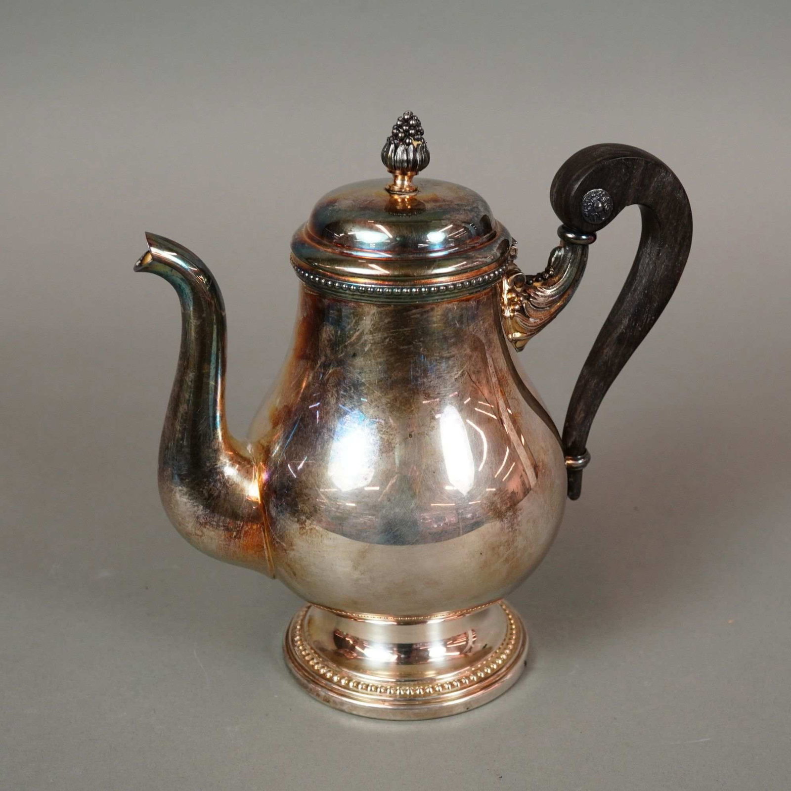 Christofle France Perles Silver-Plated Teapot: A silver-plated teapot in the Perles pattern by the French manufacturer Christofle. This piece reflects the Empire style, characterized by its pear-shaped body, pedestal foot, and ornate foliate