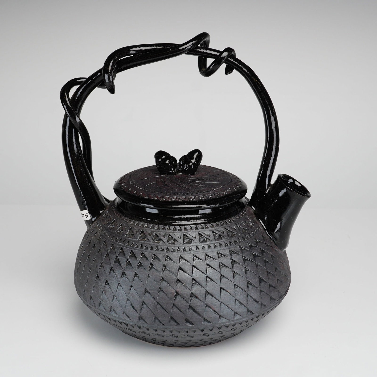 Suzanne Crane Contemporary Stoneware Teapot: A contemporary stoneware teapot by American ceramicist Suzanne Crane. The vessel features a compressed globular body decorated with an intricate incised geometric relief pattern in a repeating