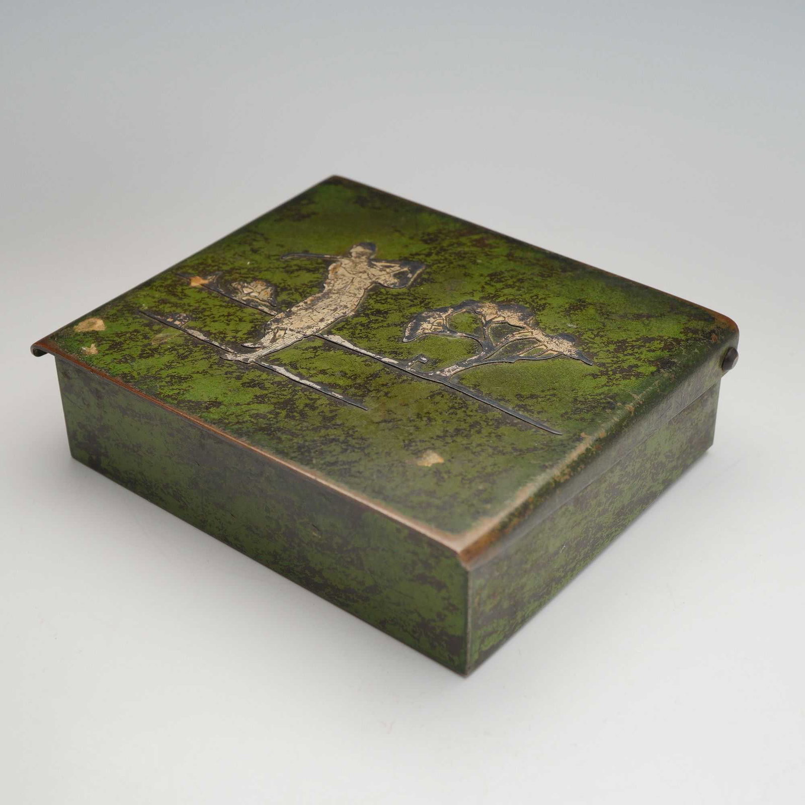 Heintz Arts and Crafts Sterling Silver on Bronze Golfer Motif Treasure Box: This Arts and Crafts period treasure box or cigarette box was produced by the Heintz Art Metal Shop of Buffalo, New York. The rectangular bronze container features a dark green verdigris patina and