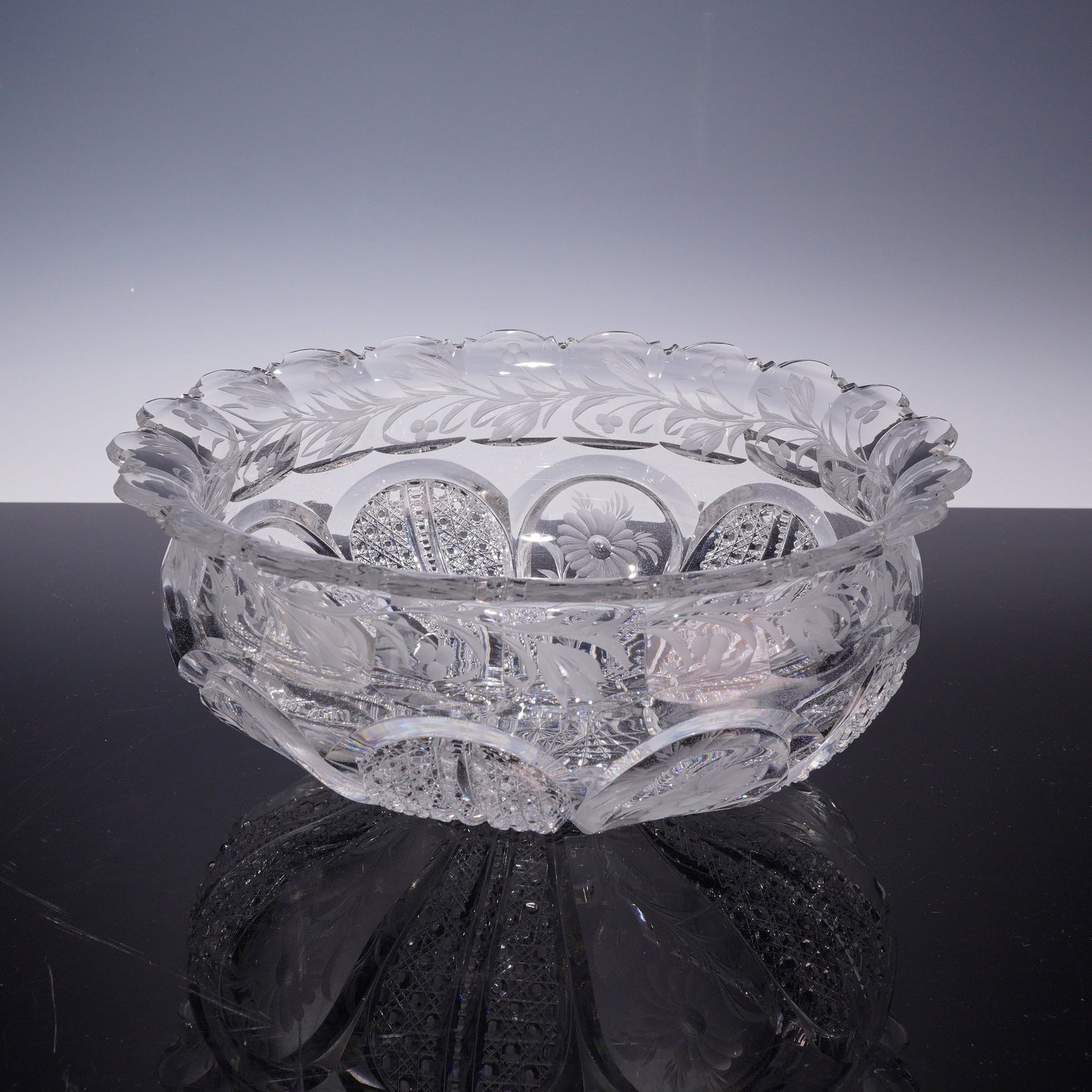 American Brilliant Period Style Faceted Crystal Centerpiece Bowl with Etched Design: A large, circular centerpiece bowl crafted from heavy lead crystal, featuring a sophisticated faceted and etched design. The bowl exhibits the high clarity and prismatic light refraction characteristi