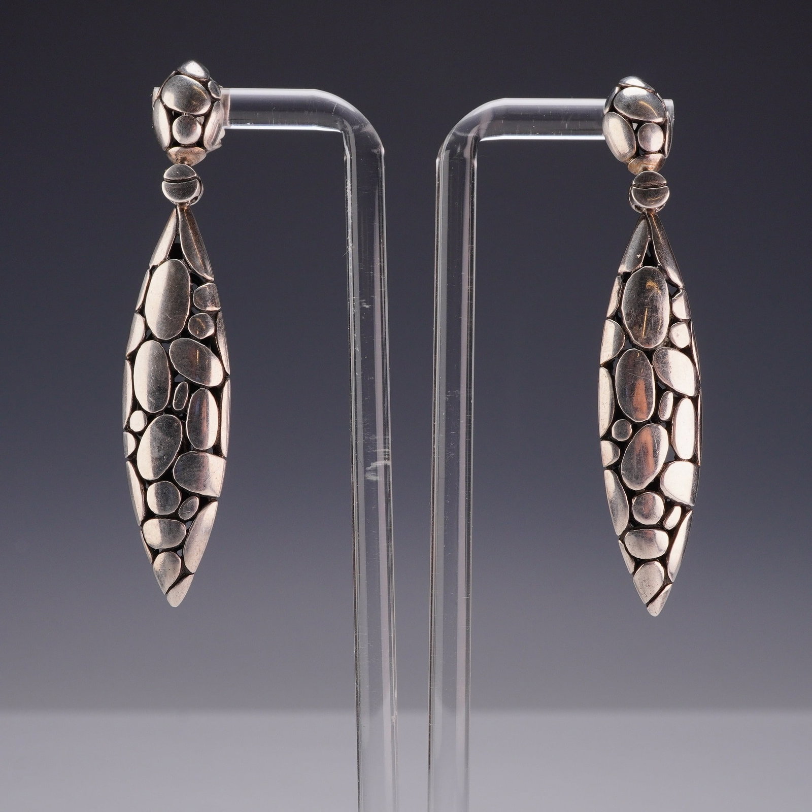Pair of John Hardy Sterling Silver Kali Pebble Marquise Drop Earrings: A matched pair of John Hardy sterling silver drop earrings from the Kali collection. Each earring features an elongated marquise-shaped drop with a high-relief pebble motif on the front surface. The r