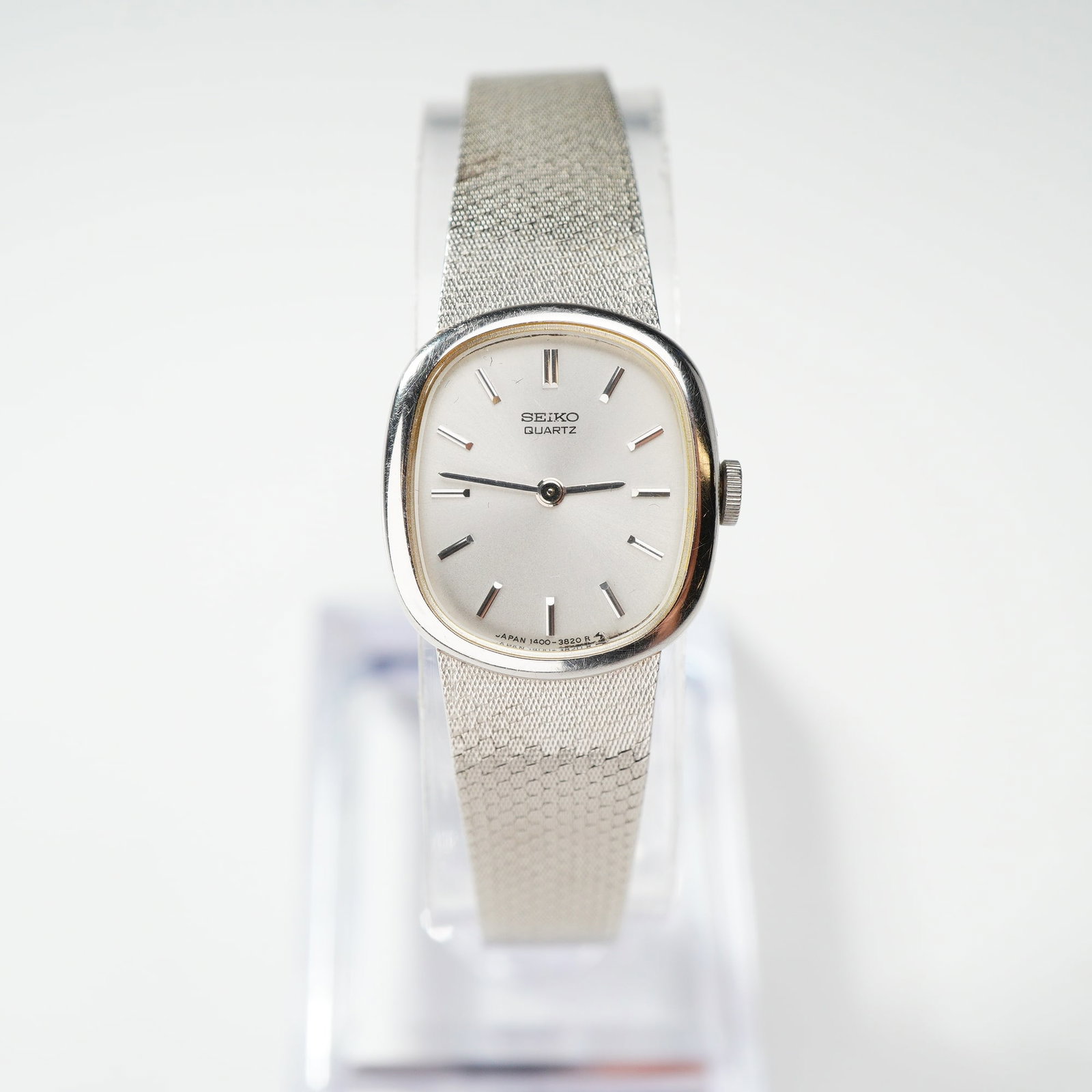 Seiko Women's Silver-Tone Quartz Dress Watch 1400-7160: Seiko women's quartz dress watch. This timepiece features a cushion-shaped case crafted from palladium-plated (PDP) base metal with a stainless steel case back. The silver-tone sunburst dial is detail