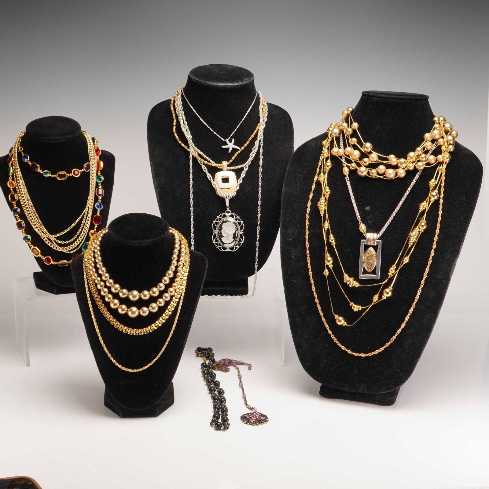 15pc Costume Jewelry Necklaces and Pendants Collection: This lot features a collection of 15 assorted costume jewelry necklaces and pendants in a variety of styles, designs, and materials. Included are multiple gold-tone chain necklaces showcasing rope, cu