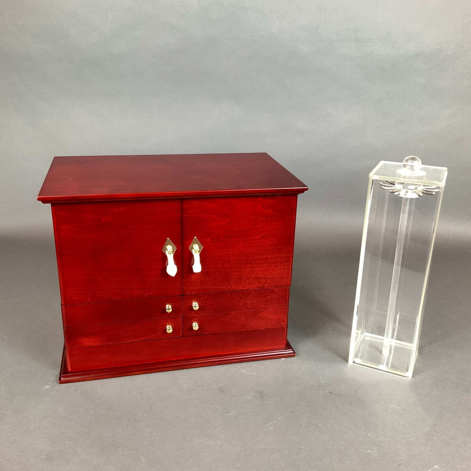 2pc Lori Greiner Jewelry Drawer and Acrylic Jewelry Carousel Stand: This lot features two jewelry storage components from the Lori Greiner "For Your Ease Only" collection. The primary piece is a multi-compartment jewelry drawer constructed of wood with a cherry