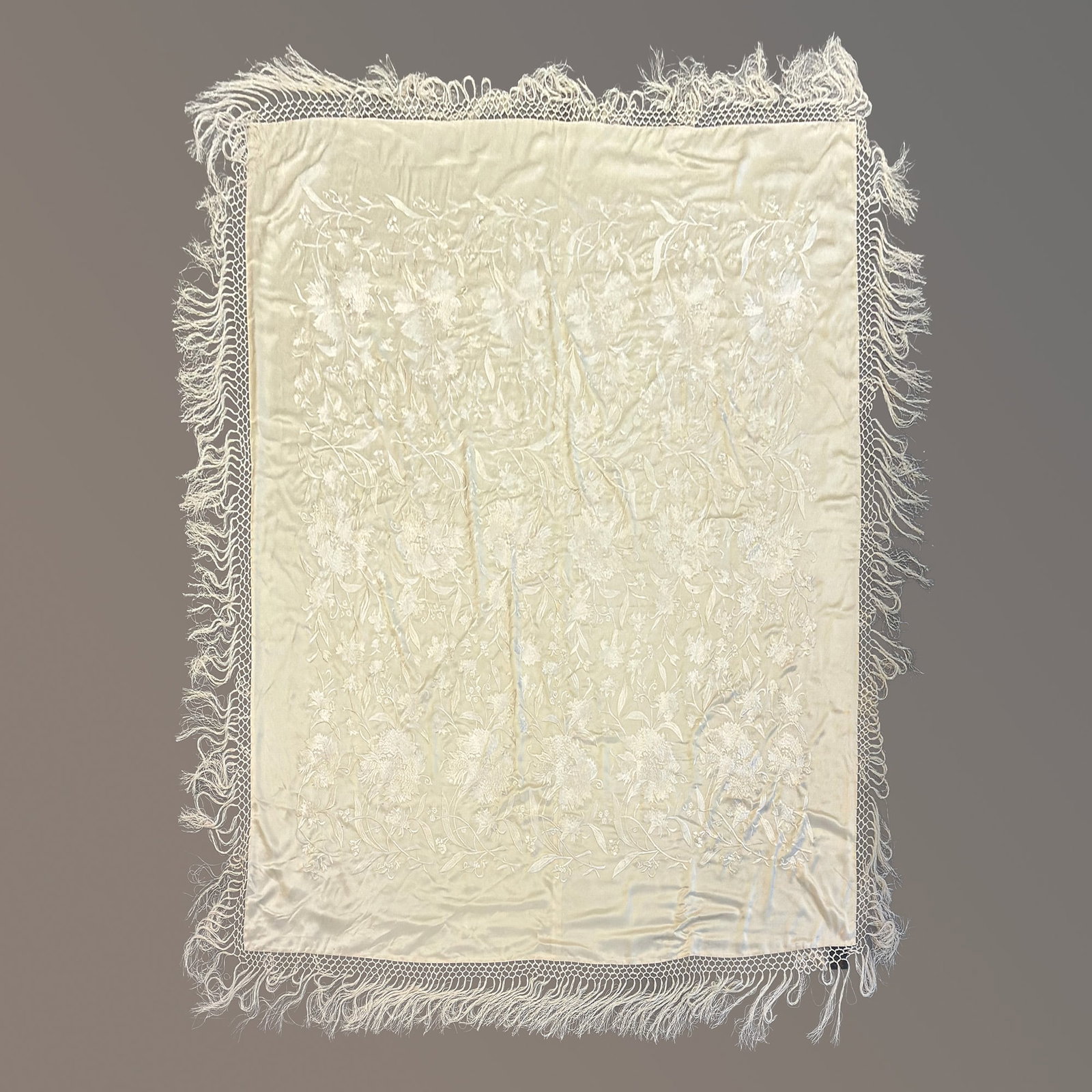 Ralph Lauren Home Embroidered Silk Floral Piano Shawl: A Ralph Lauren Home embroidered silk piano shawl throw in a cream color palette. The textile is constructed from a heavy silk ground featuring dense, tone-on-tone floral embroidery throughout the cent