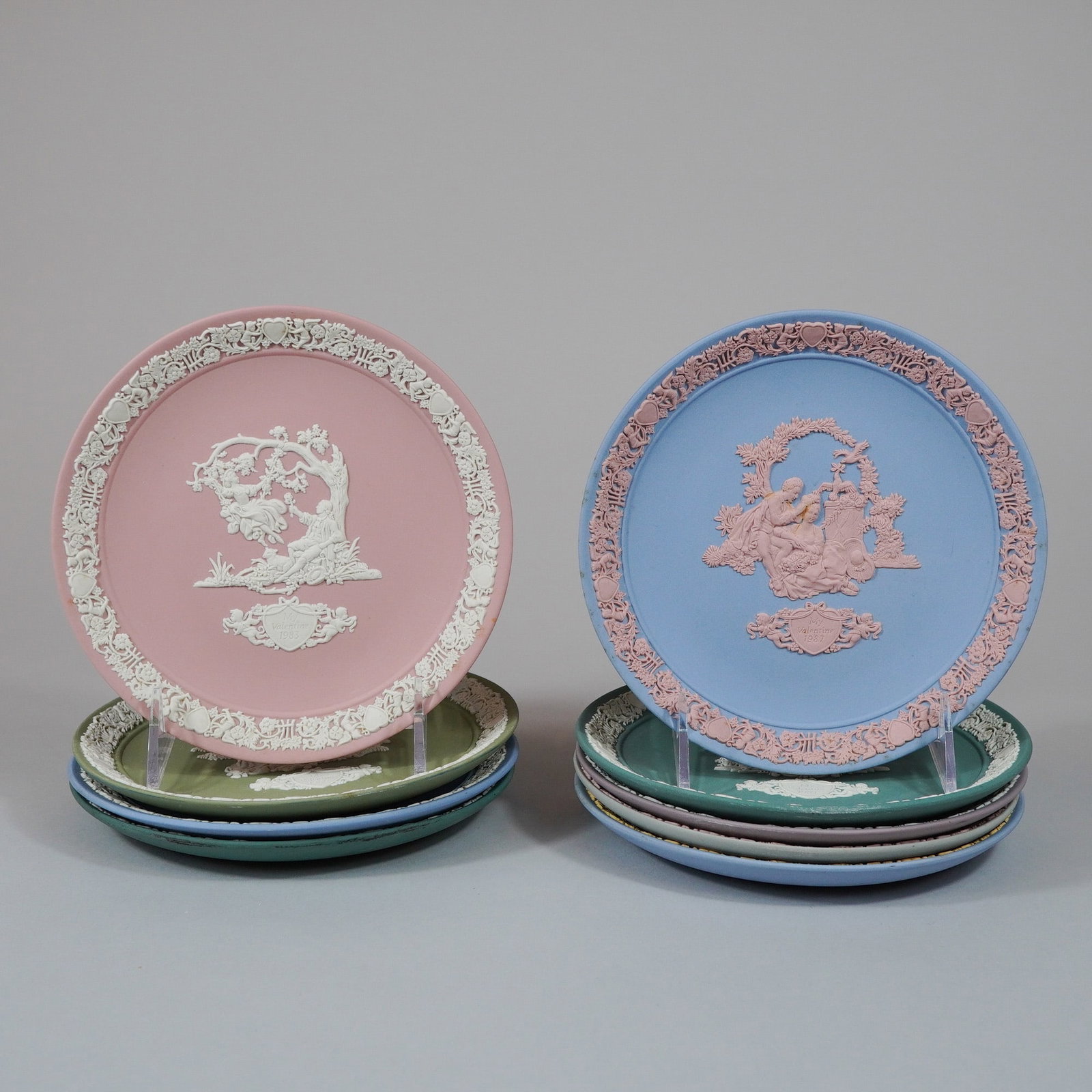 9pc Wedgwood Jasperware Valentine's Day Annual Collectors Series Plates: A group of nine Wedgwood Jasperware decorative plates from the annual limited edition Valentine's Day collectors series, manufactured in England. These stoneware pieces feature sprigged bas-relief dec