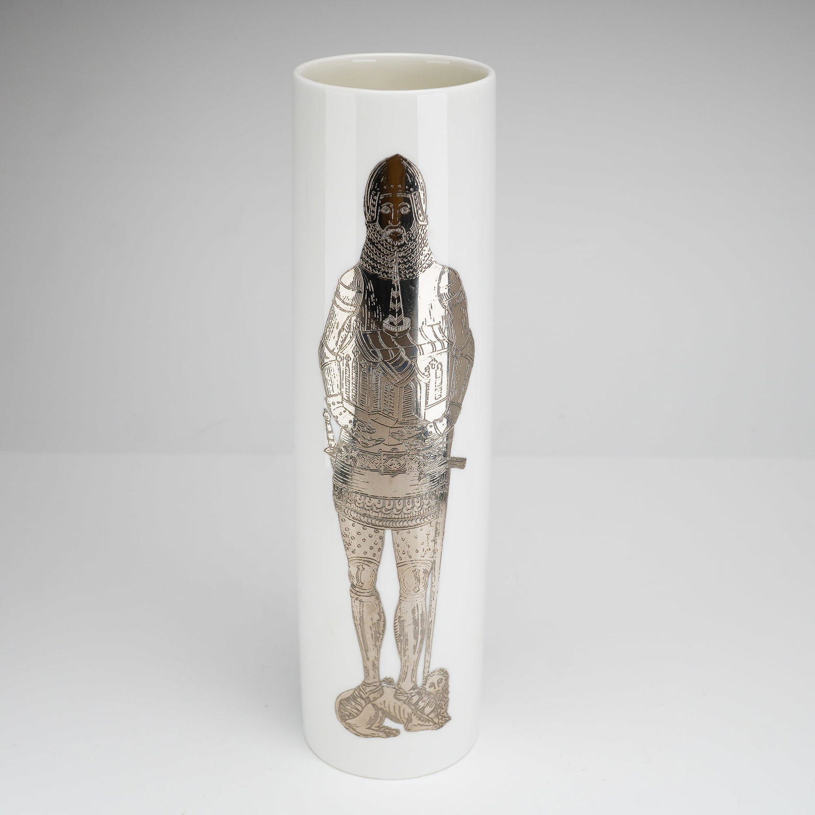 Wedgwood Bone China Medieval Knight Sleeve Vase: This tall, cylindrical sleeve vase is crafted from white bone china with a high-gloss glaze, produced by Wedgwood in England. The front of the vessel features a silver metallic transfer print depictin