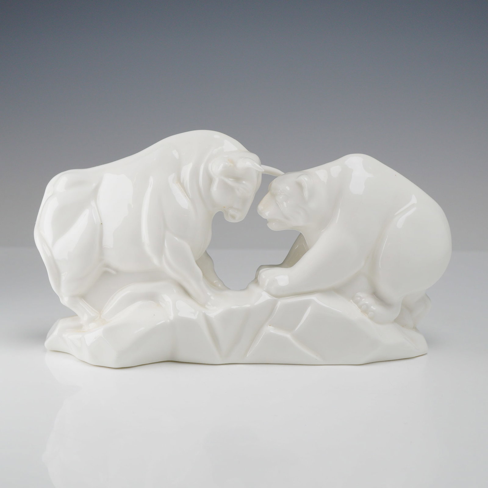 Wedgwood Bone China Bull and Bear Figurine: This Wedgwood bone china figurine depicts the stock market symbols of a bull and a bear in a face-to-face confrontation. The figures are modeled in a stylized, geometric fashion on a rocky, angular ba