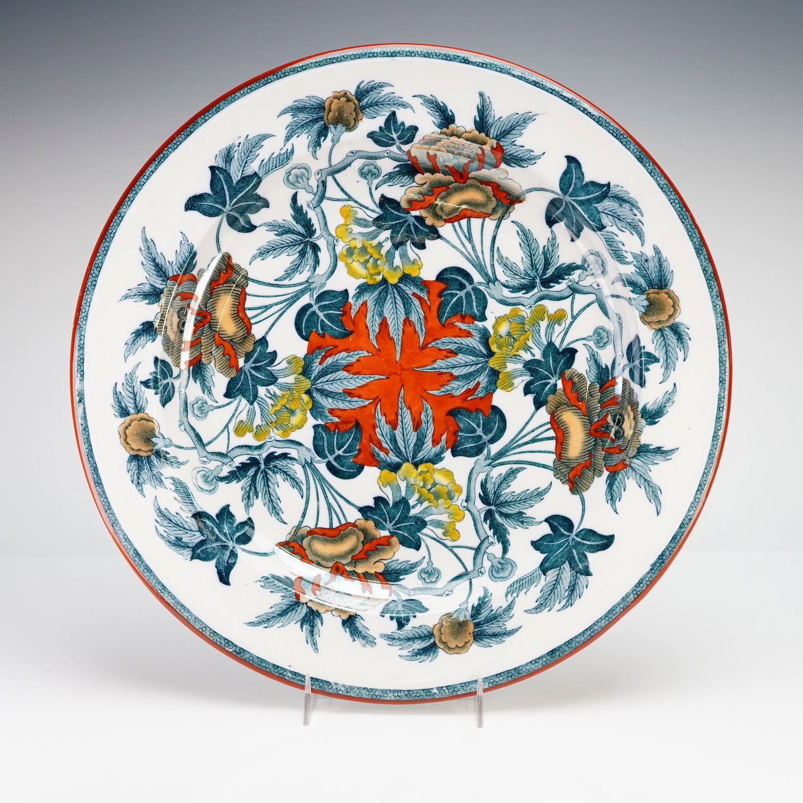 Wedgwood Etruria England Round Platter Peoney: This Wedgwood Etruria England round platter is decorated in the Peoney pattern. The ceramic charger features a polychrome transferware design on a cream-white ground. The central well is anchored by a