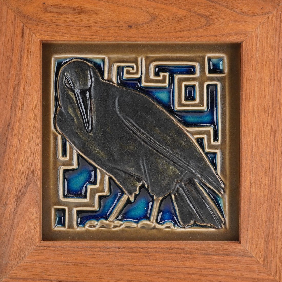 Rookwood Pottery Framed Whitman Rook Ceramic Raven Tile: A framed contemporary earthenware relief tile manufactured by the Rookwood Pottery Company of Cincinnati, Ohio. The design, titled Whitman Rook, depicts a stylized raven in the Arts and Crafts