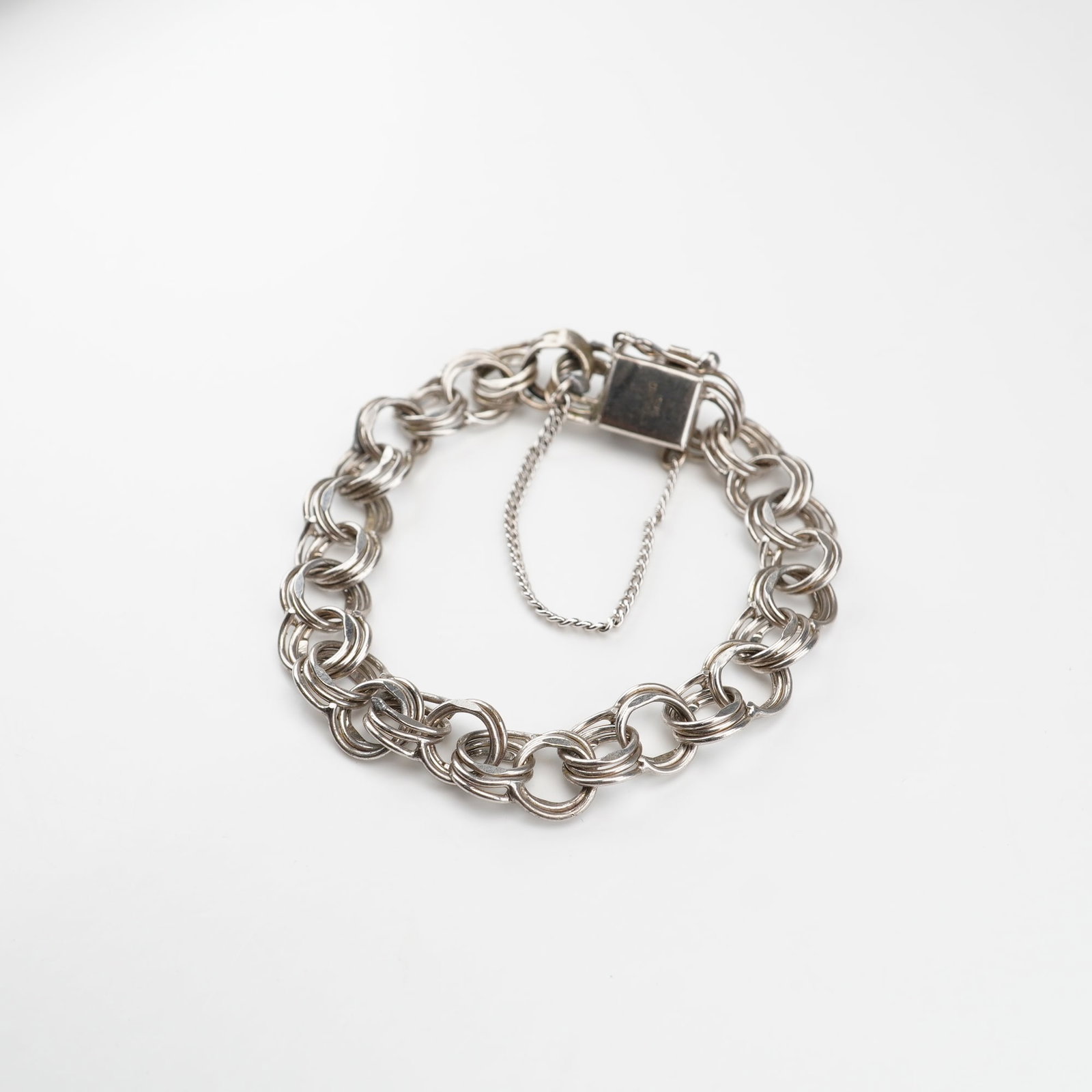 Sterling Silver Triple Link Chain Bracelet: This sterling silver bracelet features a triple link design and box clasp with a safety chain. Marked Sterling MCC on the clasp. Dimensions: 4.25"L x 0.75"W Weight: 13.27 g