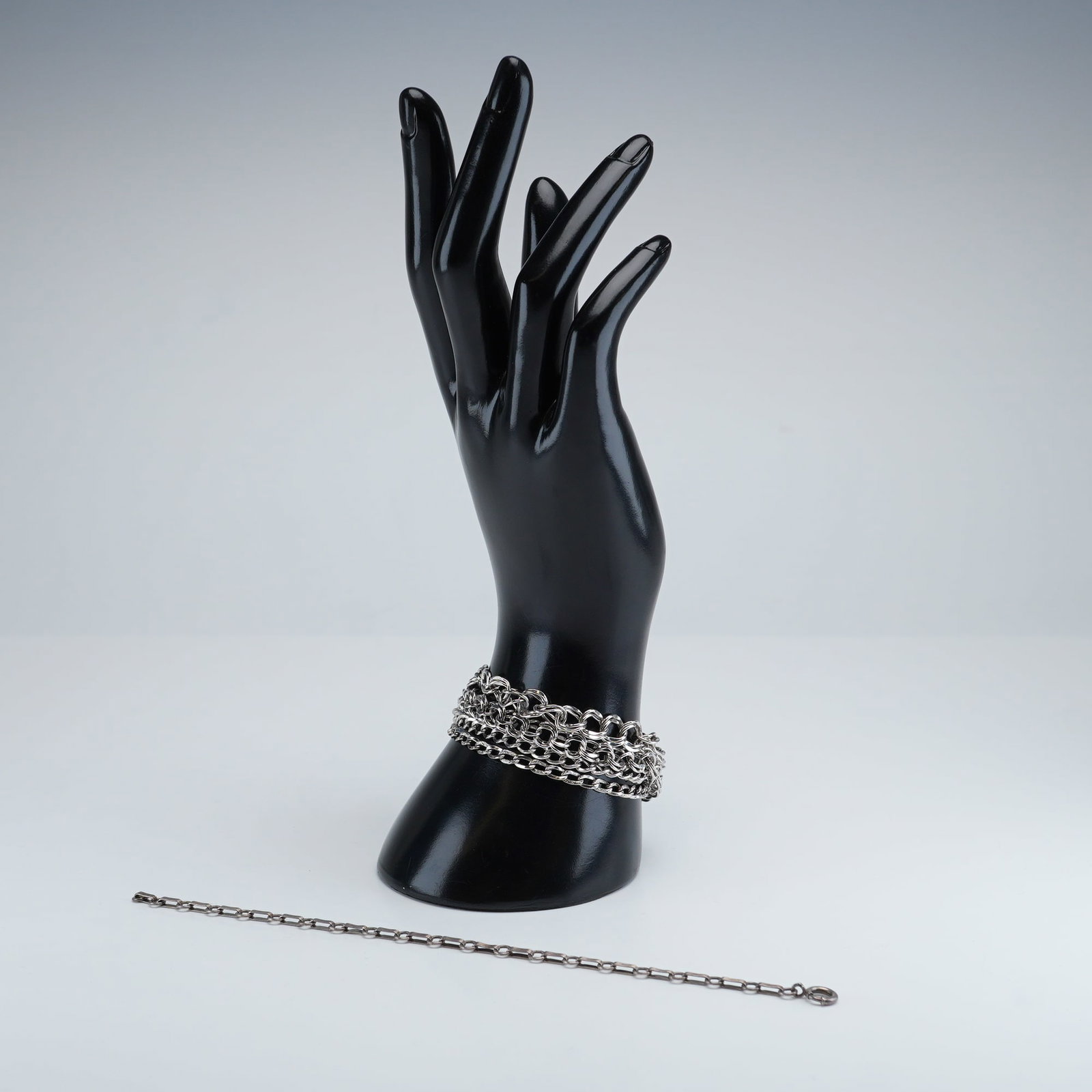 5pc Silver Chain Bracelets: A five-piece collection of silver chain-link bracelets featuring curved-link, oval-link, and paperclip-link designs. These pieces are marked Sterling but have been tested using a Thermo Scientific