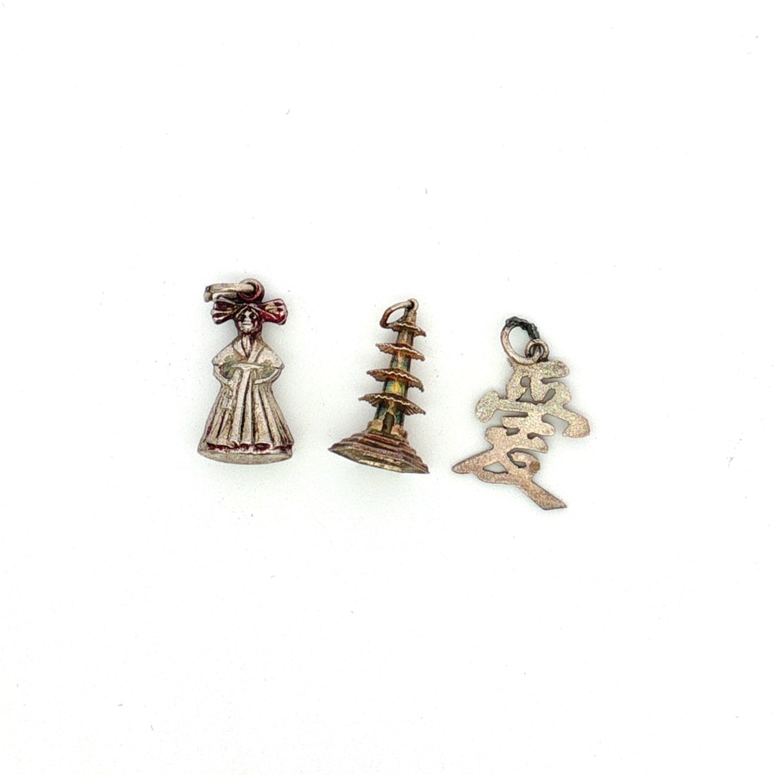 3pc Sterling Silver Chinese Character, Pagoda, and Kimono Charms: A group of three sterling silver charms depicting the Chinese character for love, a pagoda, and a woman in a kimono. Each charm is marked Sterling. Dimensions: 0.75"L x 0.75"H Weight: 2.96 g