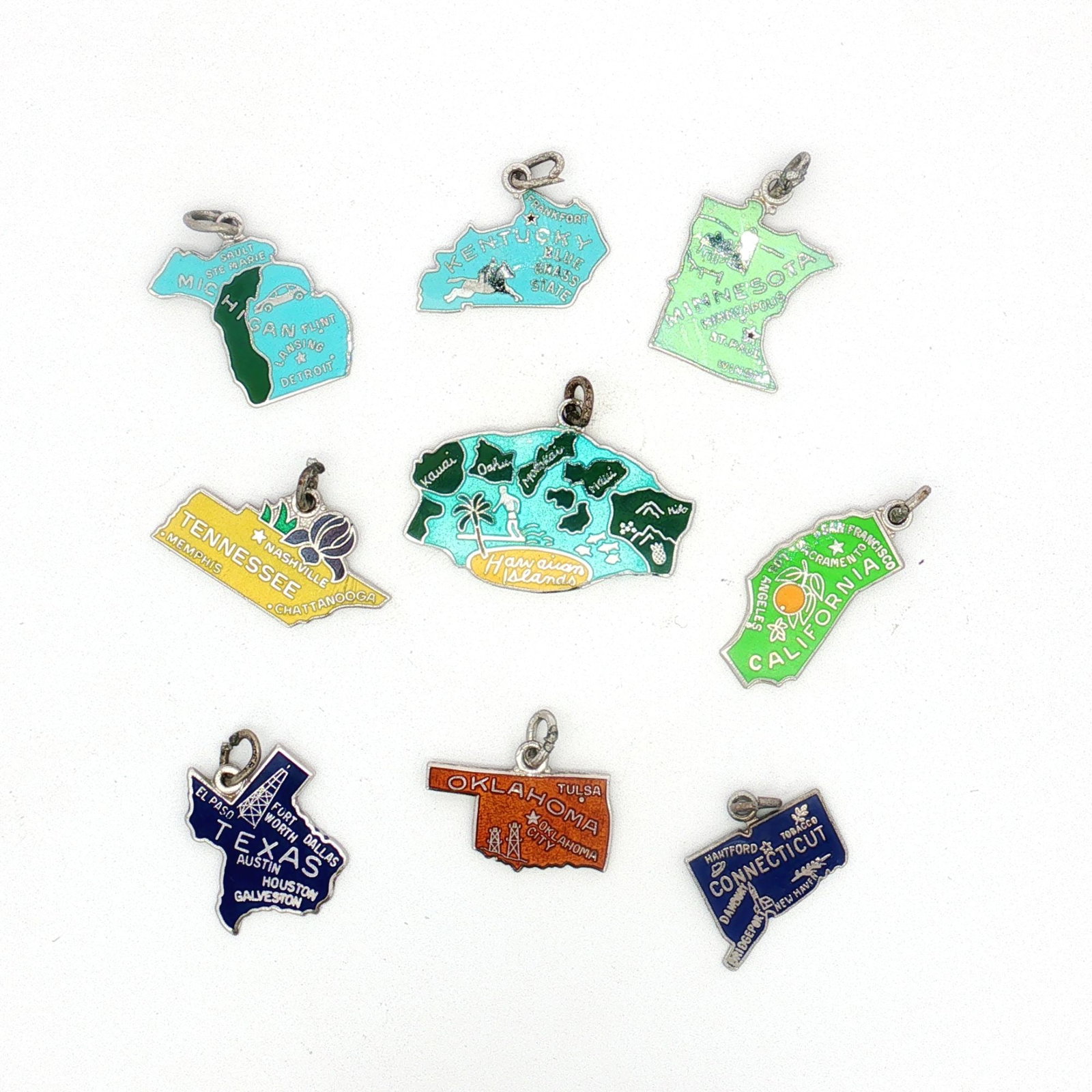 9pc Sterling Silver Enamel U.S. State Charms: A collection of nine charms featuring colorful enamel, each designed to represent a U.S. state. The states included are Tennessee, Michigan, Kentucky, Minnesota, Oklahoma, Connecticut, Texas, Californ