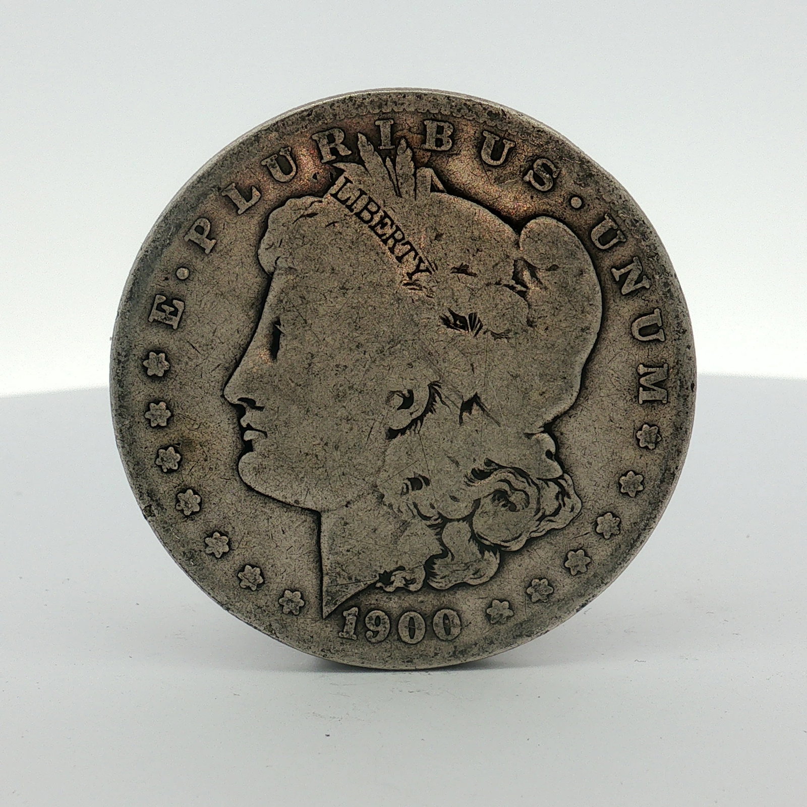 1900-S US One Dollar Morgan Silver Dollar, Circulated: This US silver dollar is a Morgan dollar struck at the San Francisco Mint in 1900. The coin is composed of 90 percent silver and 10 percent copper. It features the Morgan design on the obverse and rev