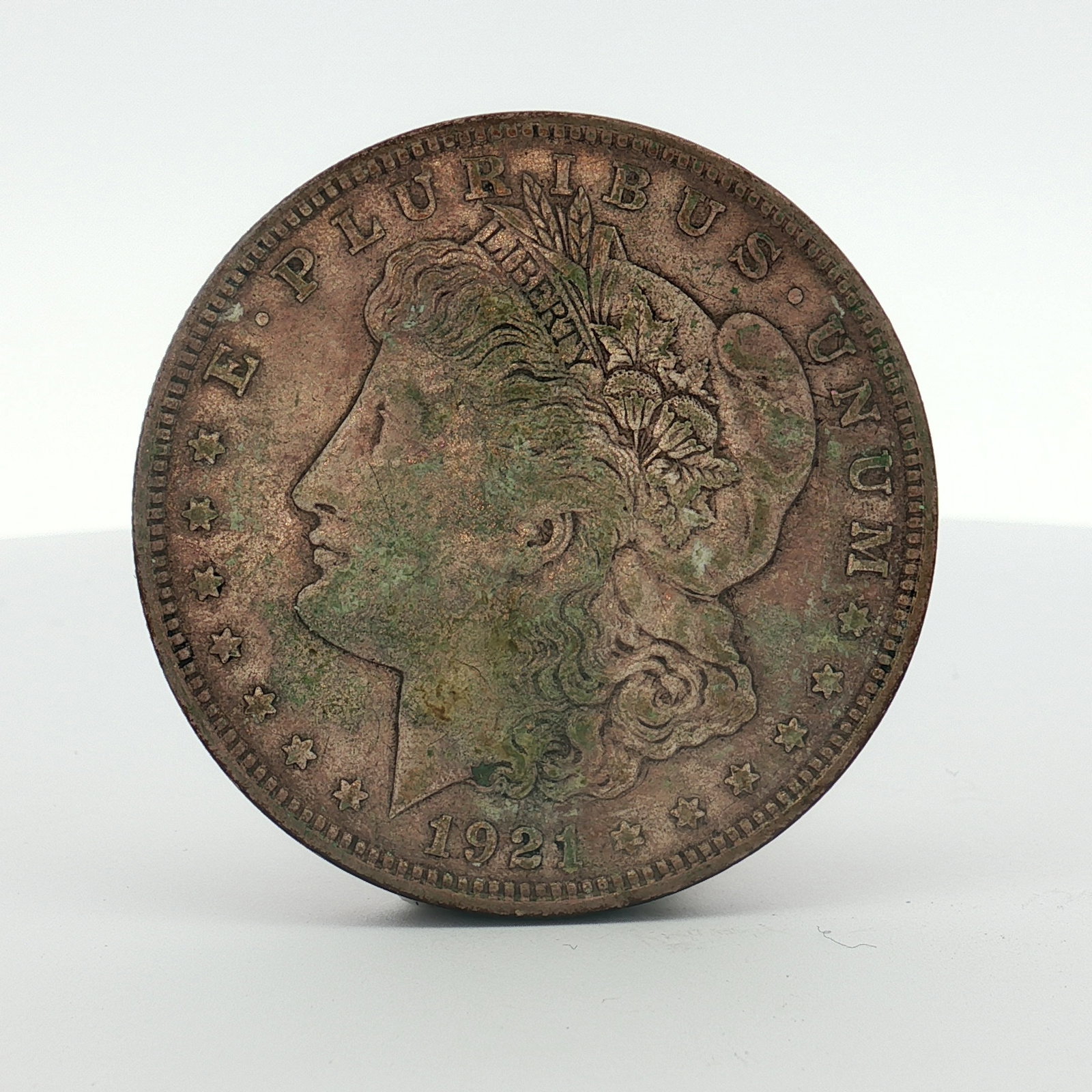 1921 US Morgan Silver Dollar Coin Circulated: This US Morgan dollar is dated 1921 and was struck at the Philadelphia Mint. The coin is composed of .900 fine silver. It features the Liberty Head obverse and the Heraldic Eagle reverse. As a 1921 is