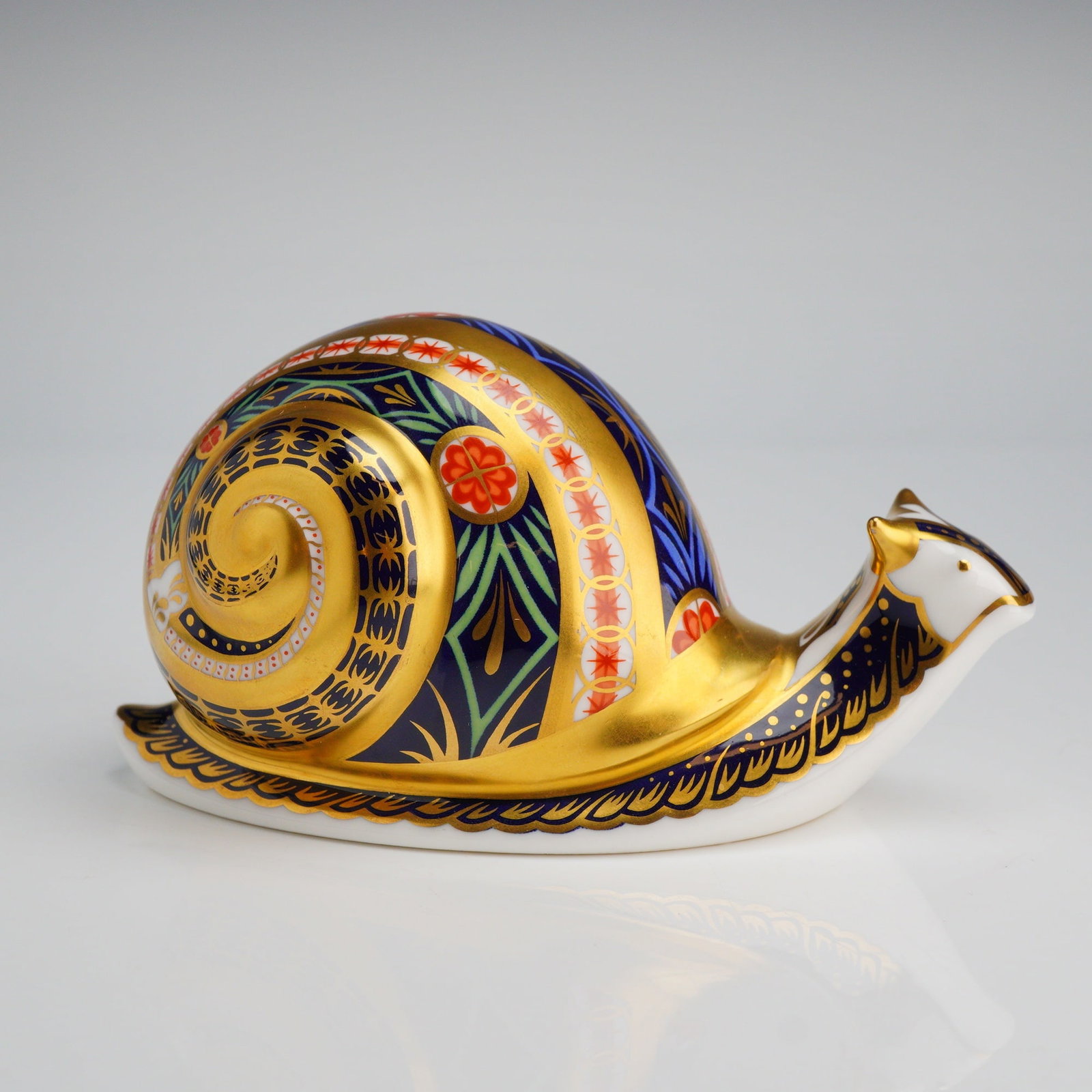 Royal Crown Derby Garden Snail Paperweight: A Royal Crown Derby fine bone china paperweight titled Garden Snail, decorated in a traditional Imari style with cobalt blue, iron red, and 22ct gold gilding. The piece was produced in England and is 