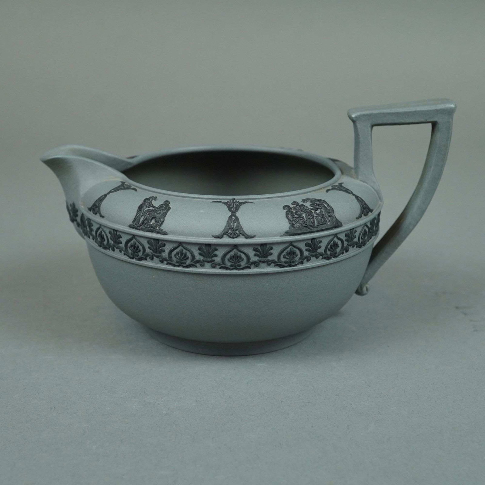 Neoclassical Style Sage Green Jasperware Creamer with Black Sprigged Decoration: Neoclassical style fine-grained stoneware creamer in the style of Wedgwood sage green jasperware. The vessel features a matte sage green body with applied black relief decoration, a technique known as
