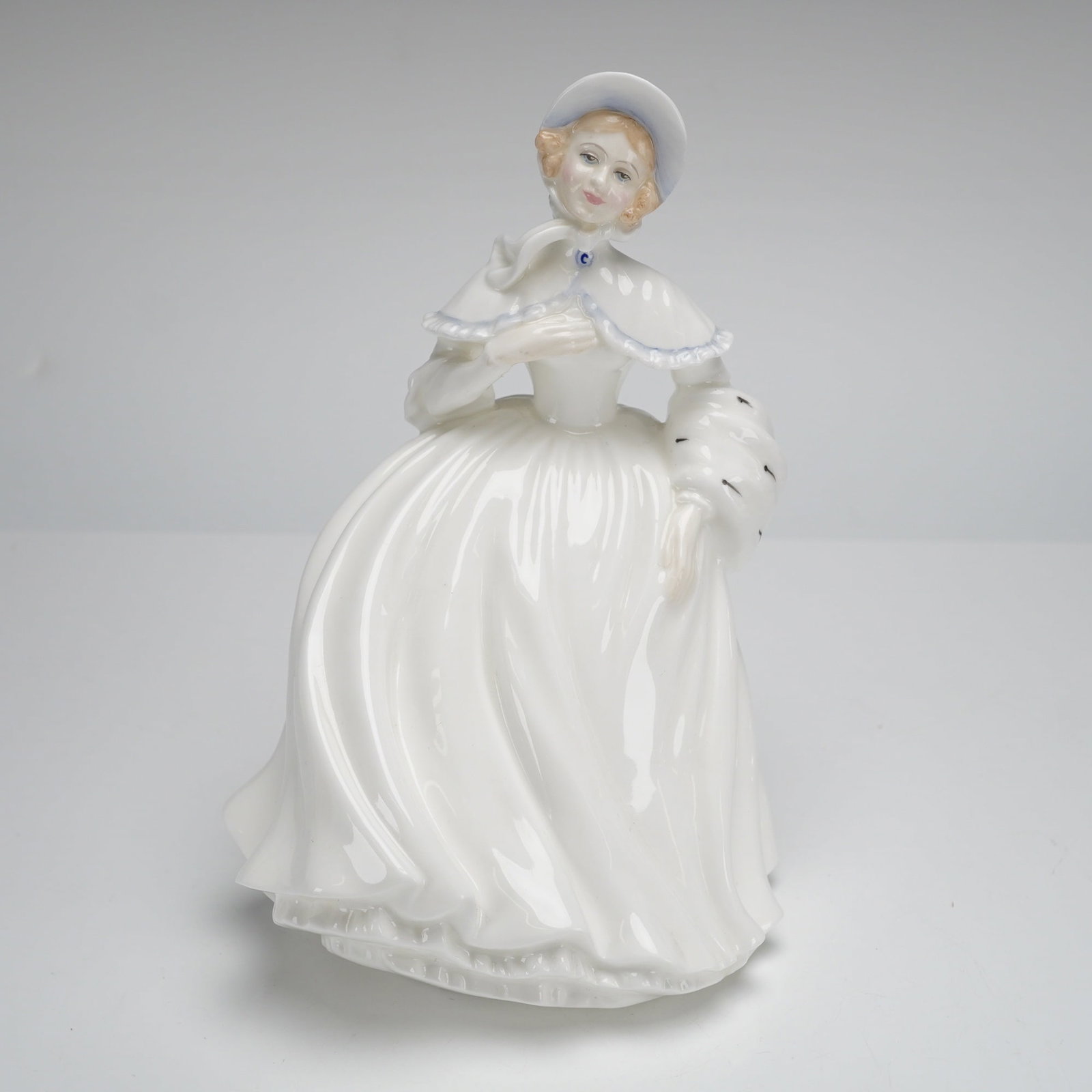 Royal Doulton Figurine, Jessica HN 3497: A glazed porcelain figurine by Royal Doulton, titled 'Jessica,' model HN 3497. The piece was modeled by Peggy Davies and depicts a woman in a late 20th-century dress, featuring a wide, flowing white s