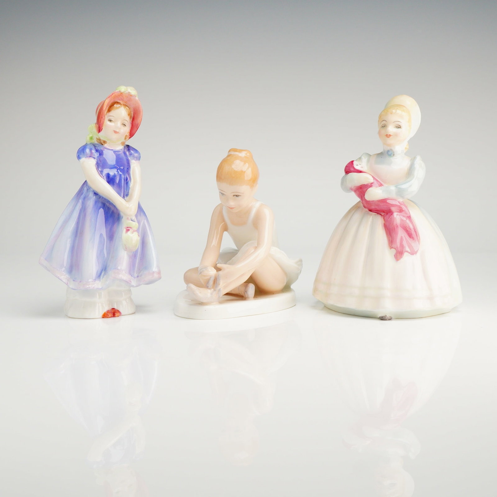 3pc Royal Doulton Figurines, The Rag Doll, Ballet Shoes, Ivy: A Trio of Royal Doulton porcelain figurines, including models The rag doll hn2142, ballet shoes hn3434, and ivy hn1768, all featuring the Royal Doulton crown logo and Doulton & Co. Limited backstamps.