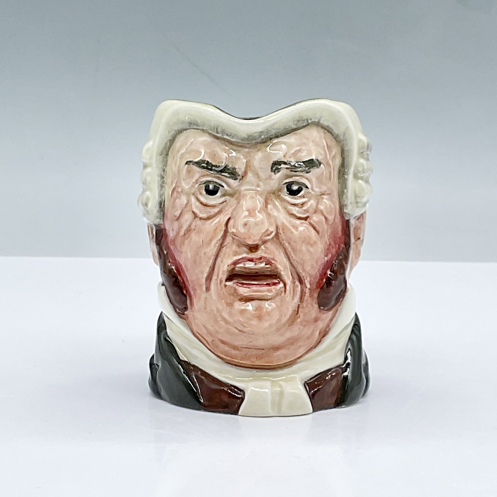 Royal Doulton Small Character Jug, Buz Fuz D5838: This glossy character jug features a white collar, brown waistcoat, dark green coat and black robe. Royal Doulton Backstamp. Dimensions: 3.75"L x 2.5"W x 3.25"H Date or Era: 1948 - 1960 Manufacturer o