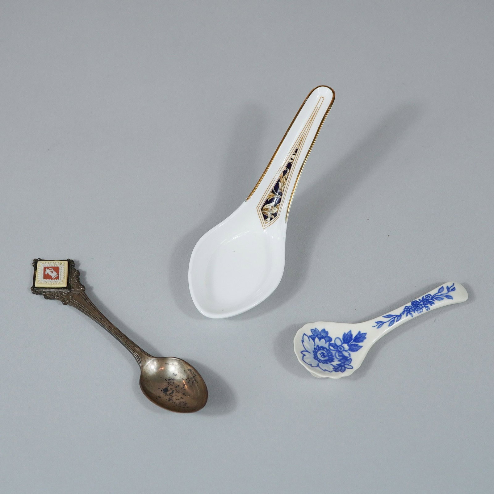 3pc Decorative Spoons Including Two Wedgwood and a Silver-Plated Souvenir Spoon: This assortment consists of a trio of decorative spoons, featuring two ceramic examples from Wedgwood and one metal souvenir spoon. The collection includes a bone china Chinese-style soup spoon with a