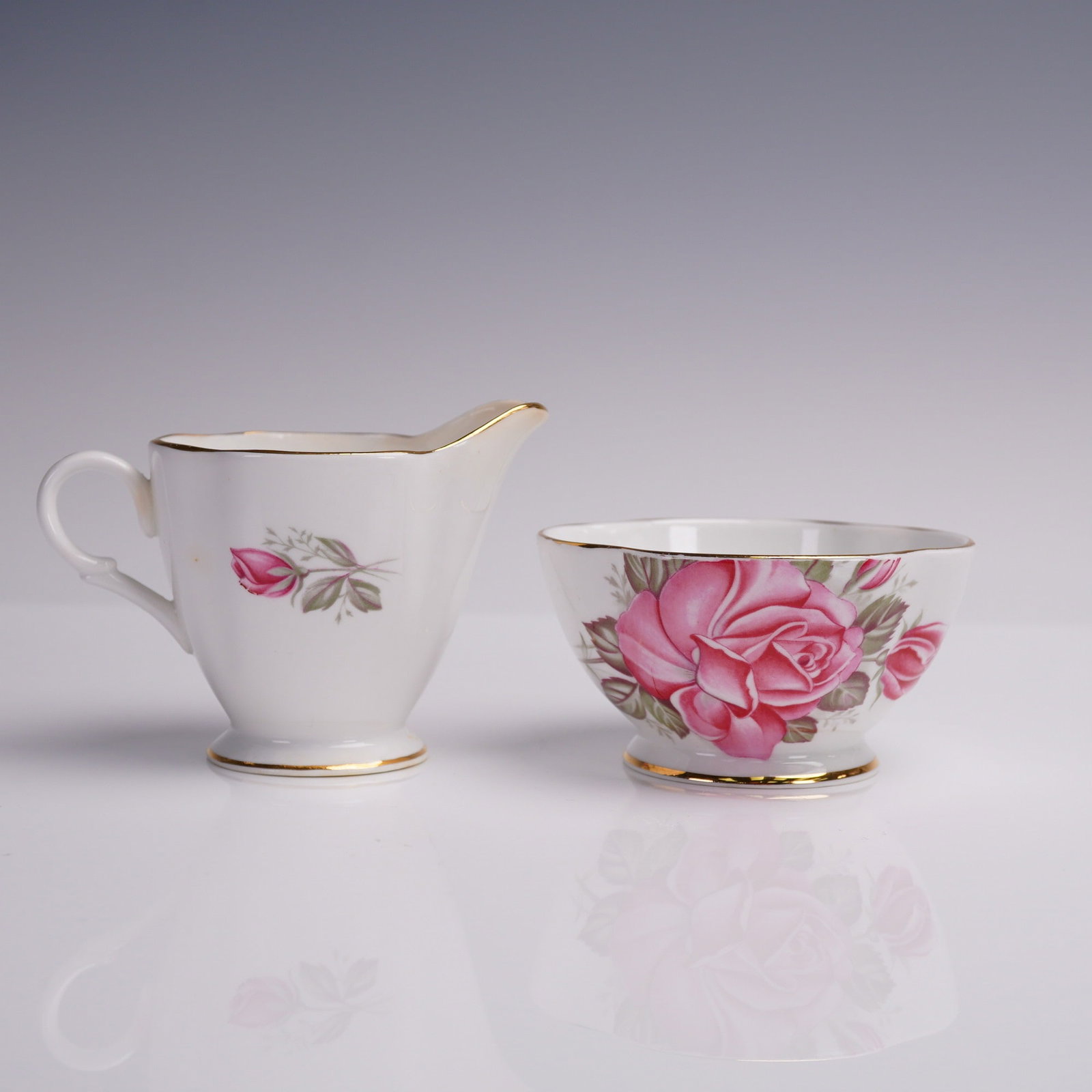 2pc Vintage Windsor Creamer and Sugar Bowl, Rose Motif: This charming vintage creamer and open sugar bowl set by Windsor Bone China features an elegant English rose motif in vibrant shades of pink, accentuated with lush green foliage. Crafted in England, e