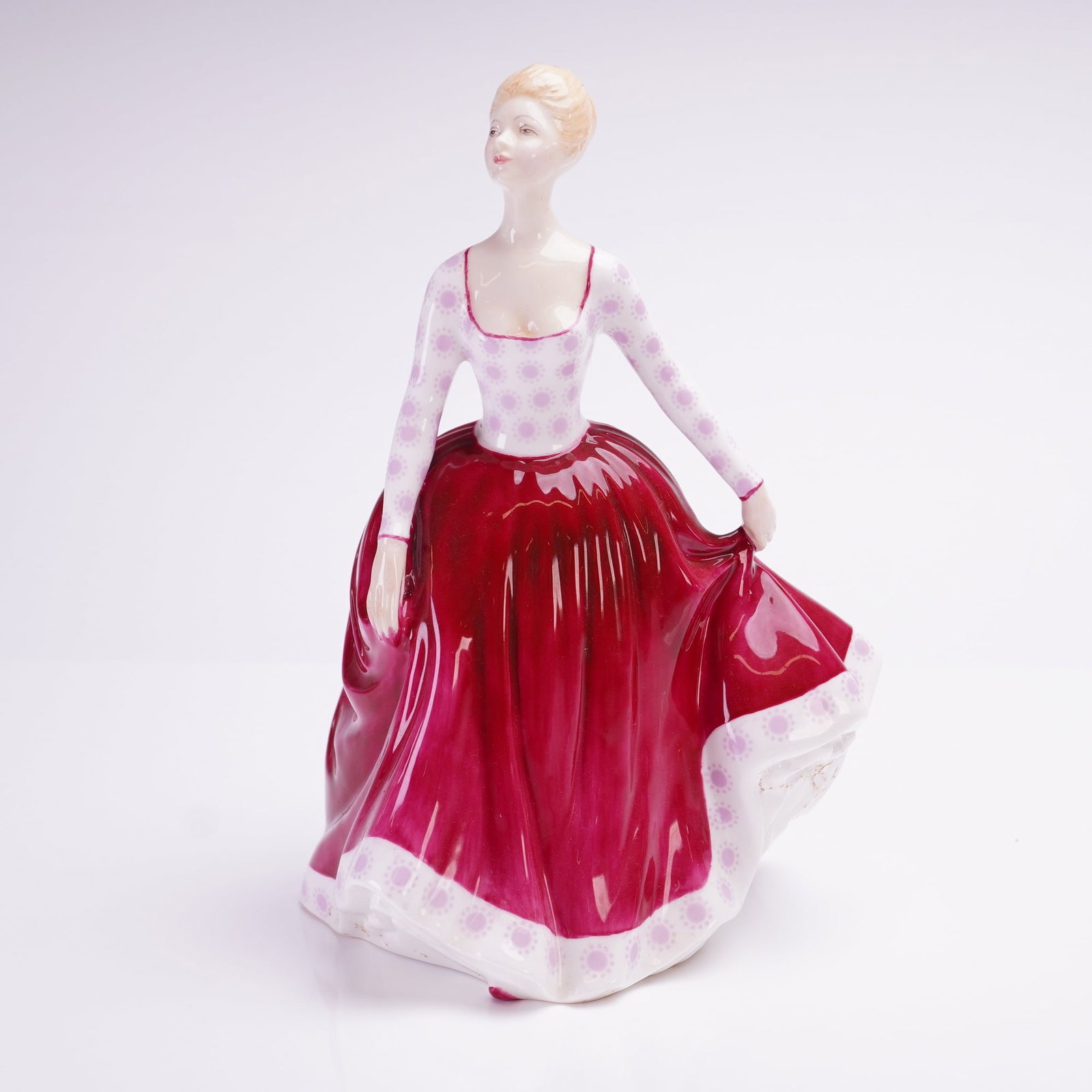 Royal Doulton Fiona HN2694 Bone China Figurine: A Royal Doulton bone china figurine titled Fiona, model number HN2694. This hand-painted figure depicts a standing woman with blonde hair styled in an updo, holding the edge of her skirt with her left