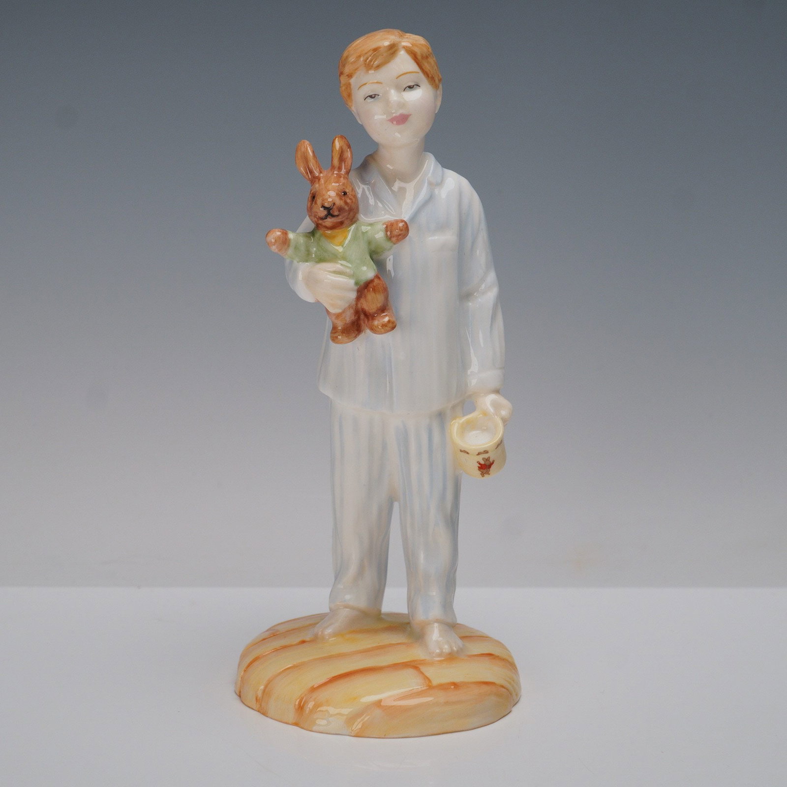 Royal Doulton Figurine, Lights Out HN4465: A bone China figurine exclusively for the International Collectors Club. This hand-made and hand-decorated piece depicts a young boy in striped pajamas, holding a teddy bear and a mug decorated with r