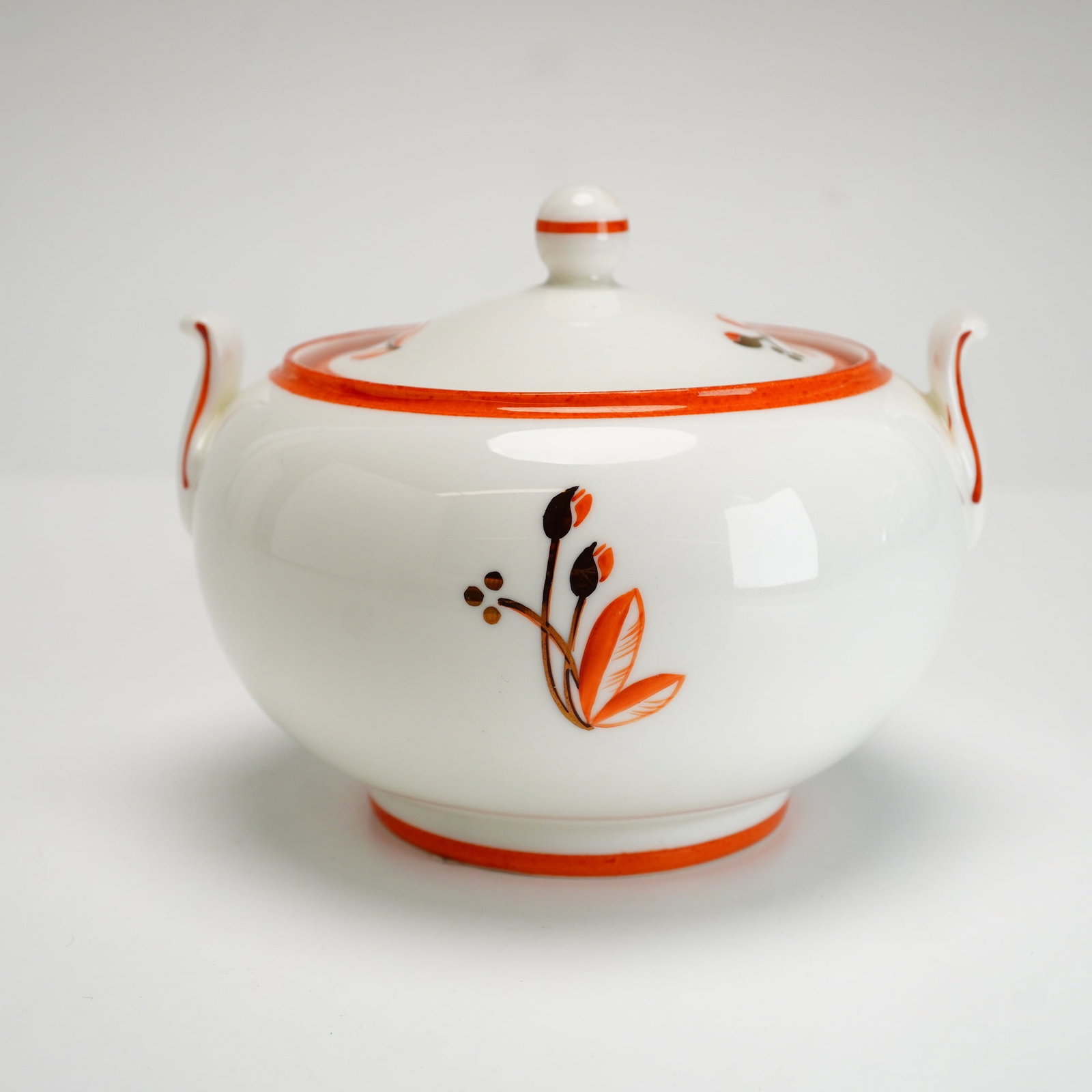 Wedgwood Keith Murray Lotus Pattern Bone China Covered Sugar Bowl: A Wedgwood fine bone china covered sugar bowl in the Lotus pattern designed by Keith Murray. The piece features a squat, rounded body with two small upturned lug handles and a coordinating domed lid t