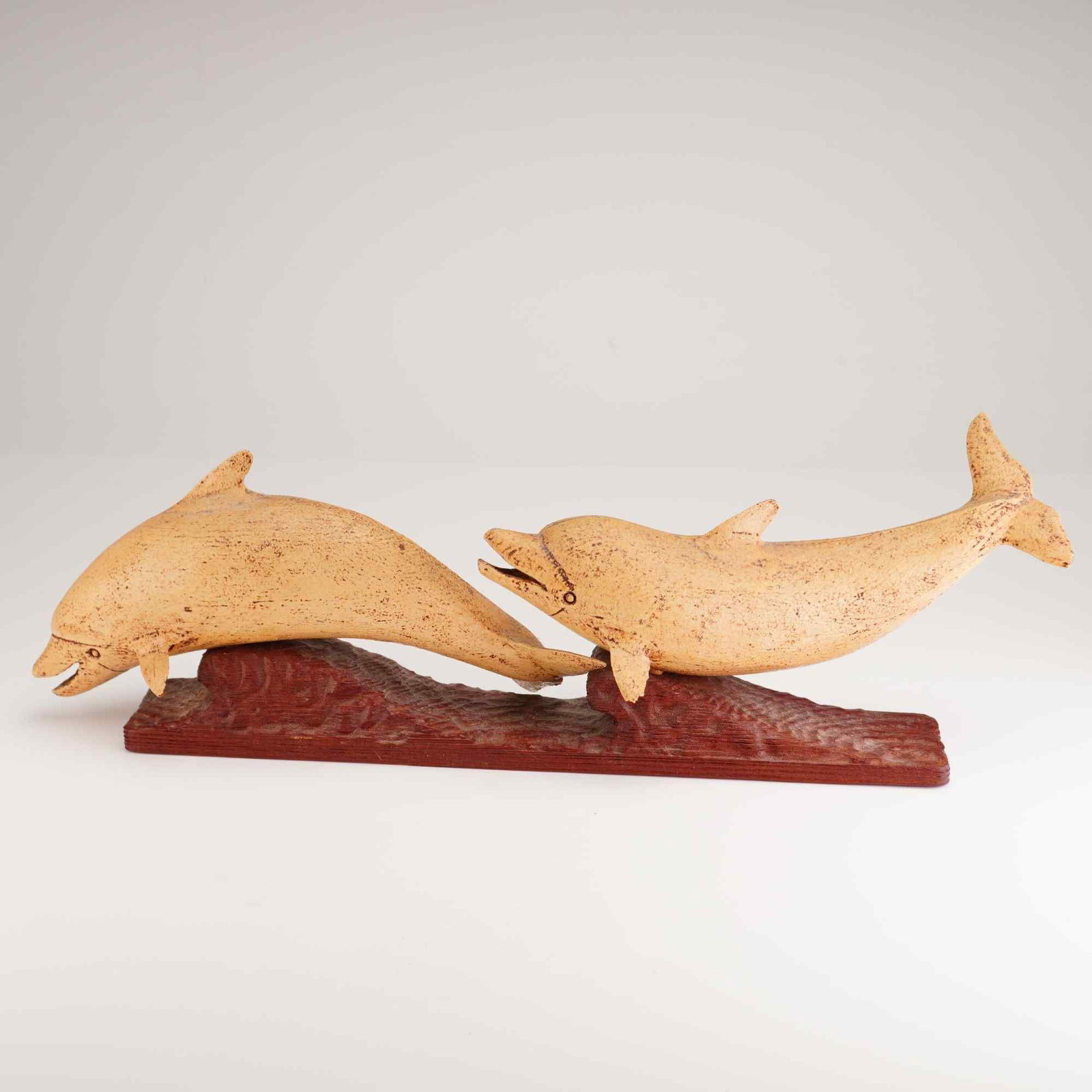 Robert I. Innis (American, 1893-1983) Carved Wood Sculpture, Dolphins, Signed: Features a hand carved and painted school of dolphins set into a stylized wood base. Signed to the bottom DOLPHINS by R. I. Innis, So. Dennis, Mass. 1968. Robert I. Innis (1893??"1983) was a prolific 