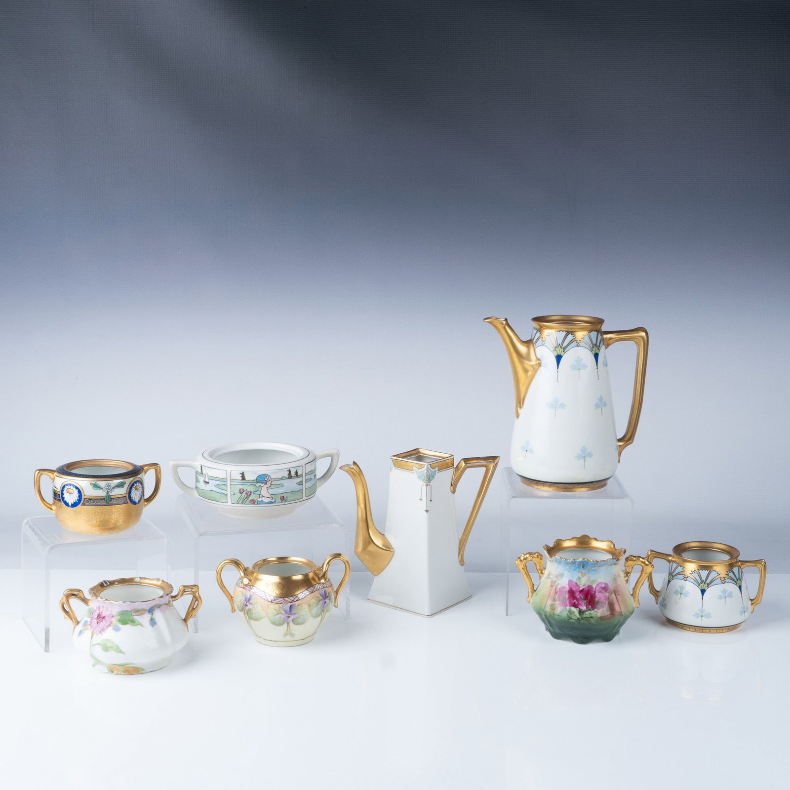 8pc Hand-Painted Limoges and Pickard Porcelain Set: Exquisite collection of hand-painted porcelain pieces, including Limoges and Pickard, showcasing intricate designs, floral motifs, and gilded accents. The set features two elegant coffee or chocolate 