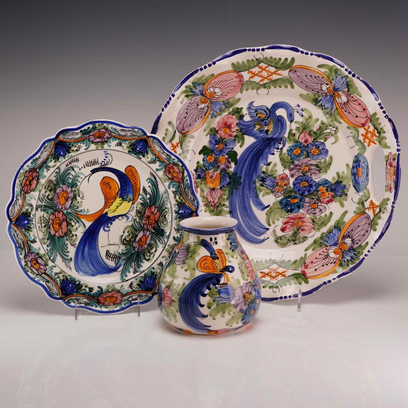 A Trio of Hand Painted Skyros Greek Ceramic Bird and Floral Tableware: This 3pc collection of Greek glazed earthenware consists of three items featuring hand-painted folk-art decoration. The group includes a small scalloped plate, a large handled tray, and a small bulbou