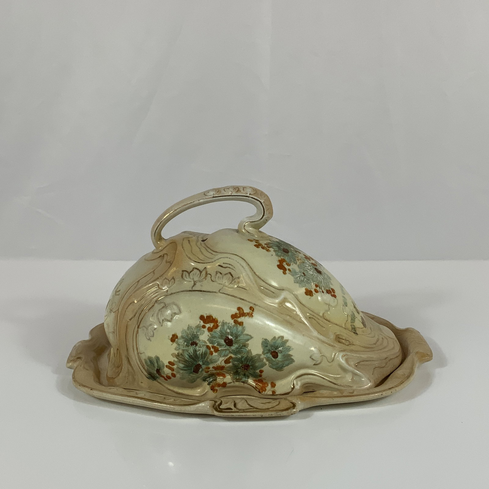 Henry Alcock English Cheese Dish: This Henry Alcock cheese keep consists of a high-domed lidded dish and a matching underplate. The set is constructed of porcelain and features an iridescent luster glaze finish. The form is characteri