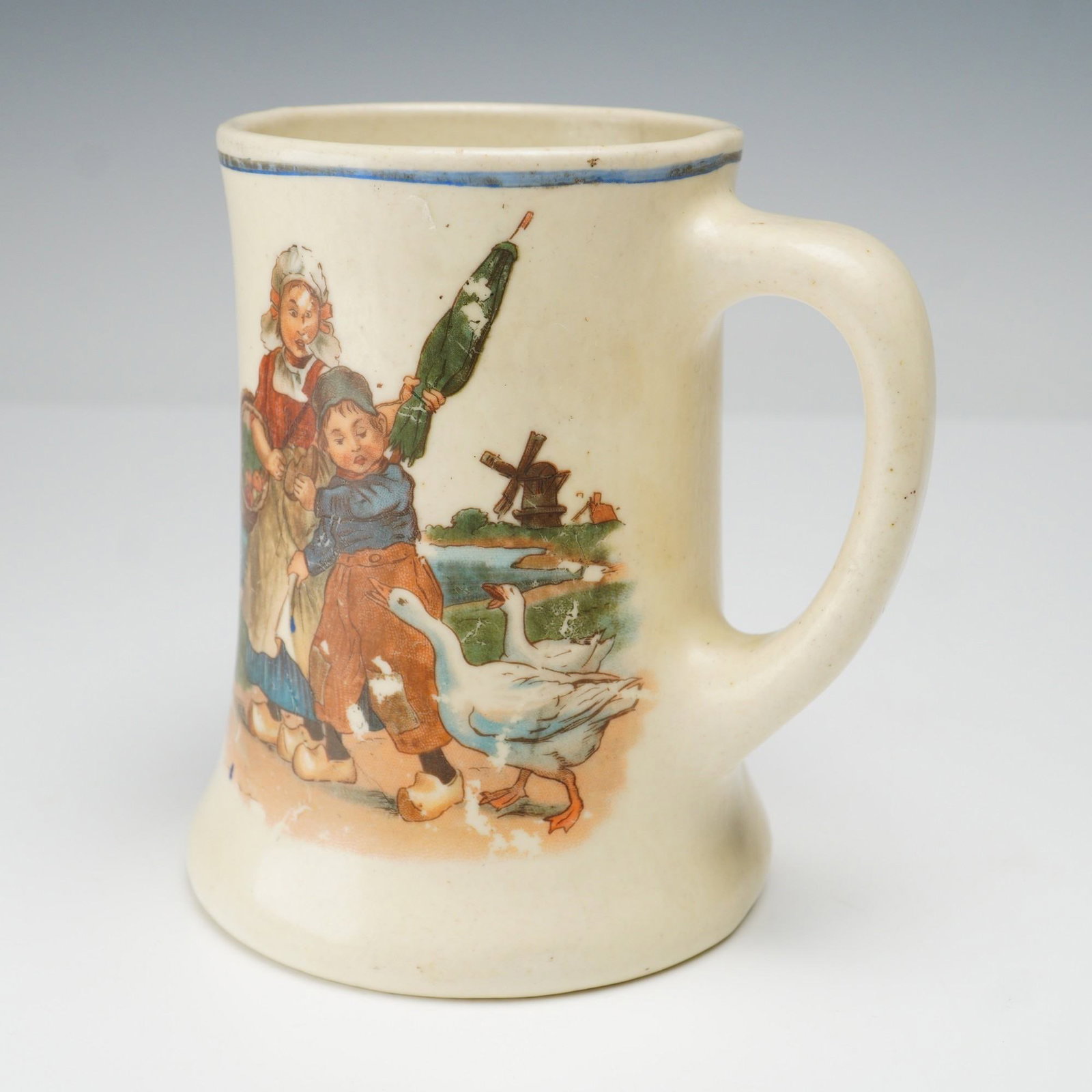 2pc Unmarked Dutch-Inspired Mugs, Fishing & Goose Girl Designs: This charming set of two unmarked mugs features Dutch-inspired scenes, with vivid hand-painted designs. One mug shows a young boy and girl fishing by the water, with the boy holding a fishing rod and 