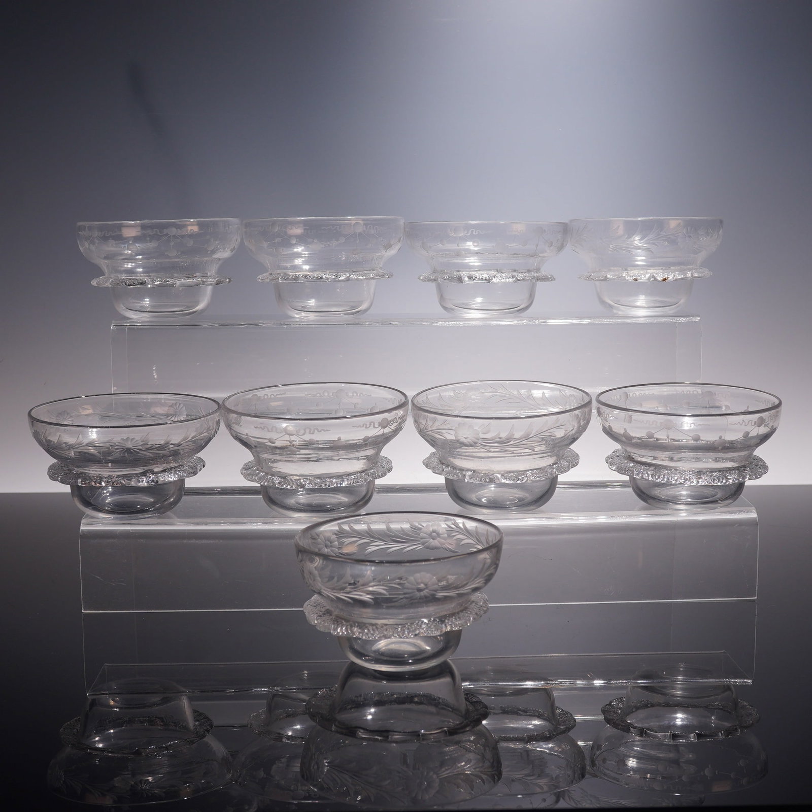 9pc Vintage Etched Glass Dessert Bowls: A charming set of nine etched glass dessert bowls, each delicately crafted with clear glass and decorated with etched floral and foliate motifs. The bowls feature a scalloped and textured band around 