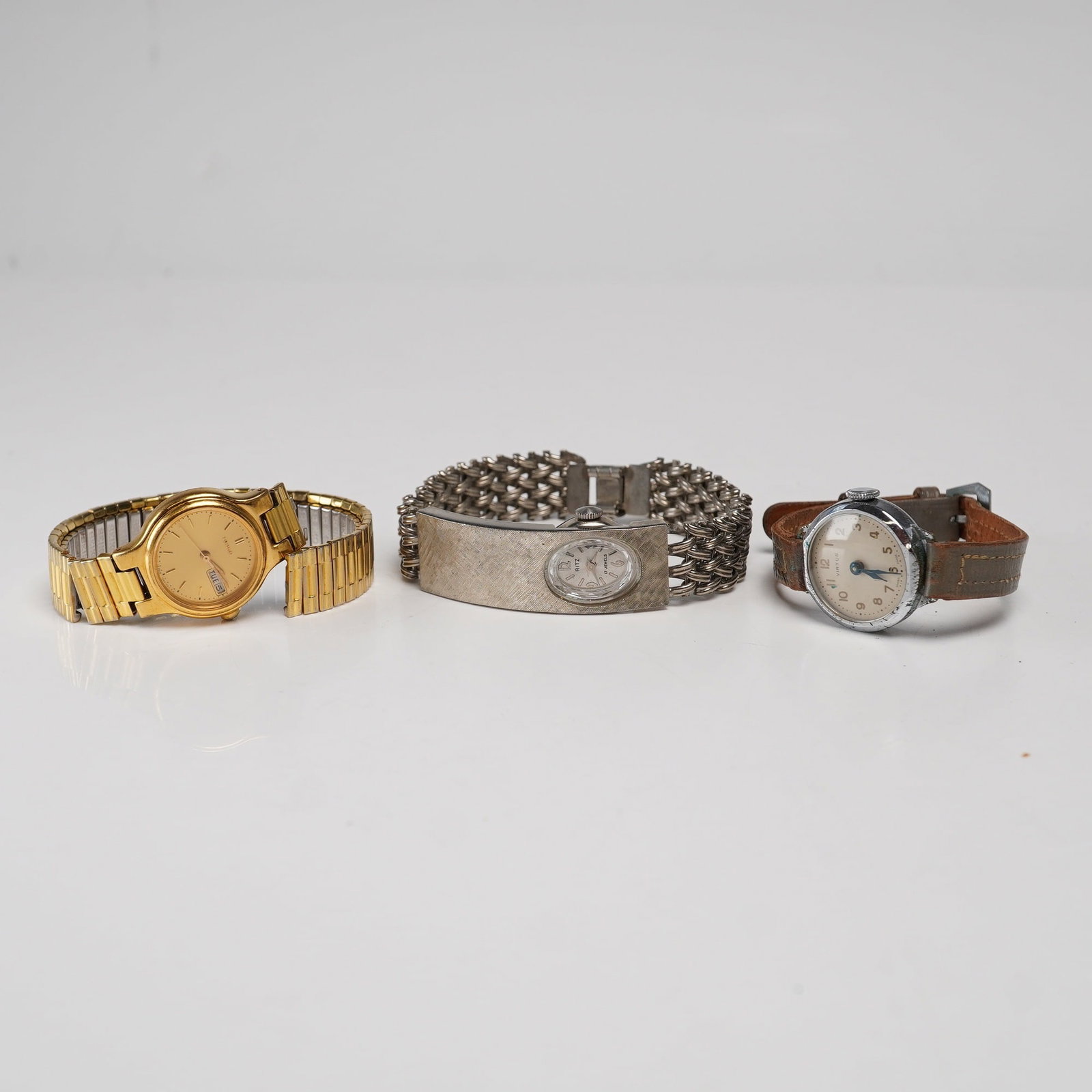 3pc Women Wristwatches Including Seiko, Ritz, and Virtus: This lot features three watches including a Seiko Quartz Day-Date, a Ritz 17-jewel manual wind, and a Virtus manual wind. The Seiko features a gold-tone base metal case with a stainless steel back and