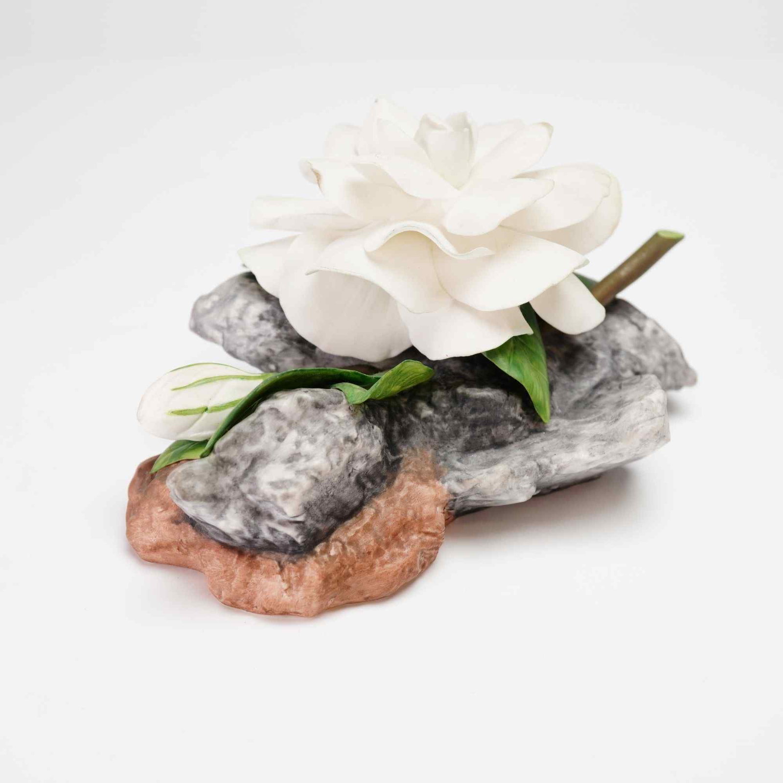 Boehm, Gardenia Flower Figurine 25012: A fine bone porcelain botanical sculpture by Boehm of England, featuring a detailed study of a Gardenia (Gardenia jasminoides). The piece showcases a large central white blossom in full bloom, accompa
