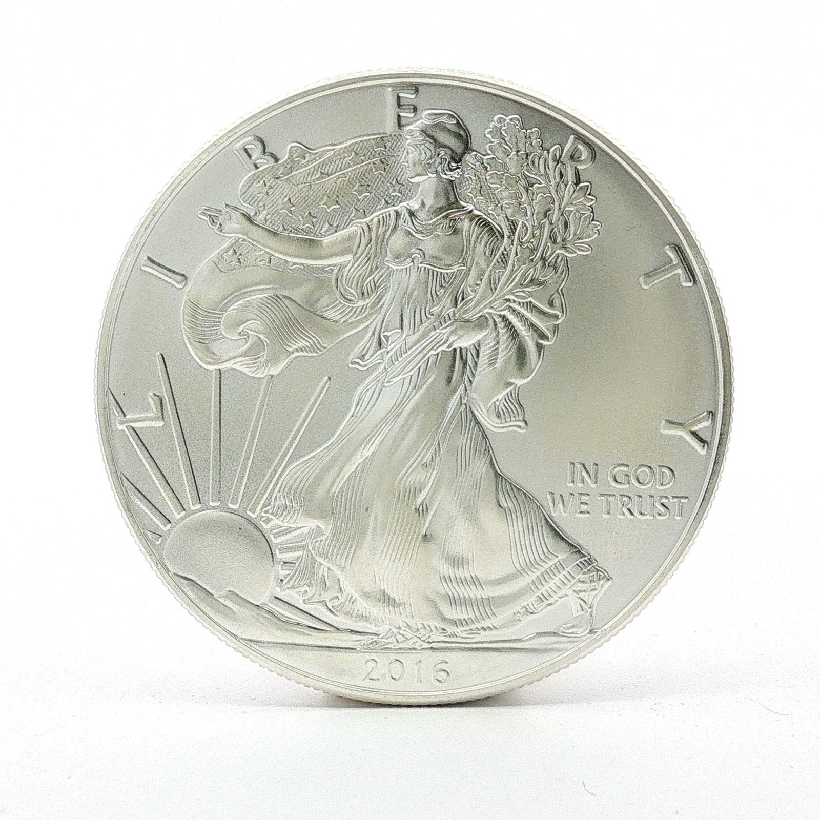 2016 U.S. American Silver One Dollar Eagle Coin: Designed with Obverse of Walking Liberty with Liberty in God We Trust 2016; reverse has heraldic eagle with shield, United States of America with 1oz. Fine Silver One Dollar. Dimensions: 40.6mm Date o