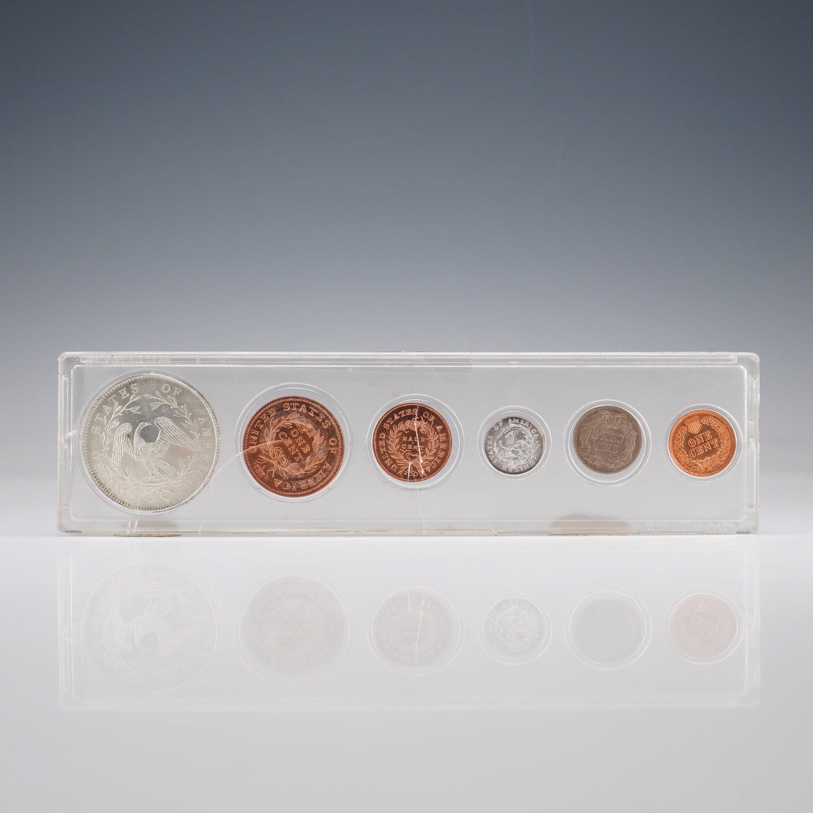 Silver and Copper Replica Set of Early U.S. Coin Designs: A modern replica coin set featuring six pieces modeled after iconic early United States coin designs, housed in a clear hard-plastic display holder. The set includes silver-tone and copper-tone copies