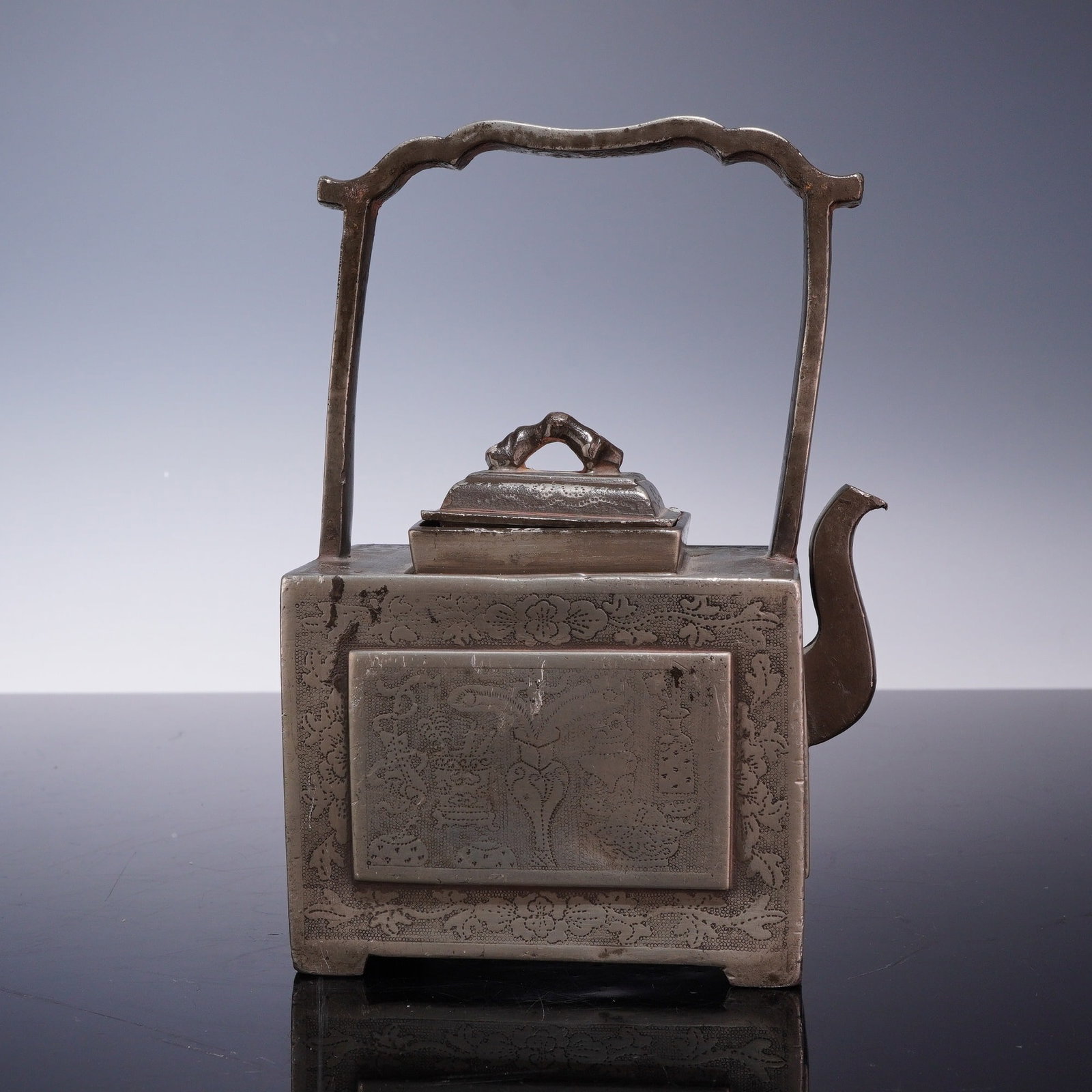 Late 19th Century Chinese Qing Dynasty Pewter Rectangular Teapot: This rectangular pewter teapot dates to the late 19th century during the Chinese Qing dynasty. The vessel is constructed with a box-shaped body resting on four integrated L-shaped feet at the corners.